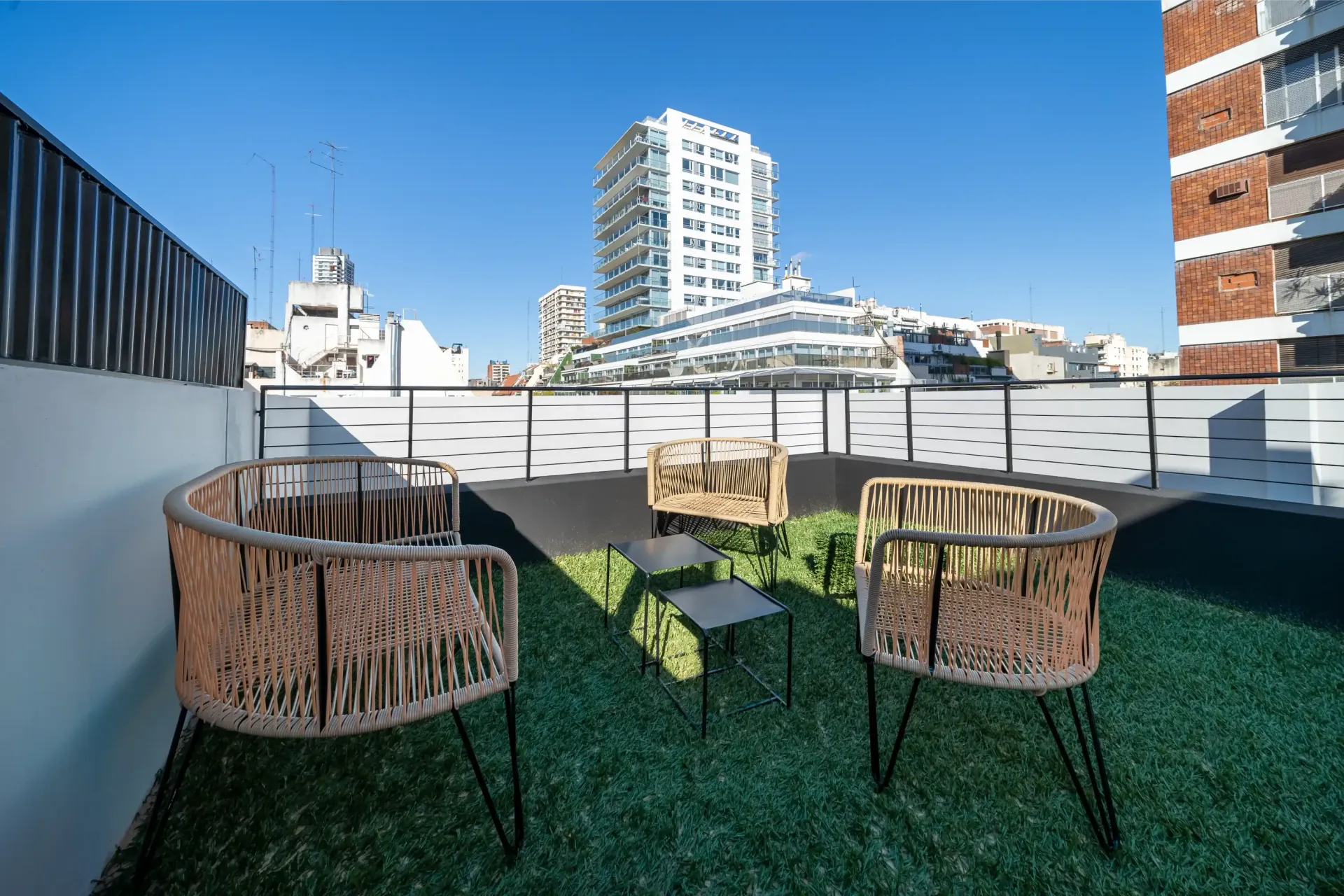 Hay dos sillas y una mesa en el techo de un edificio.