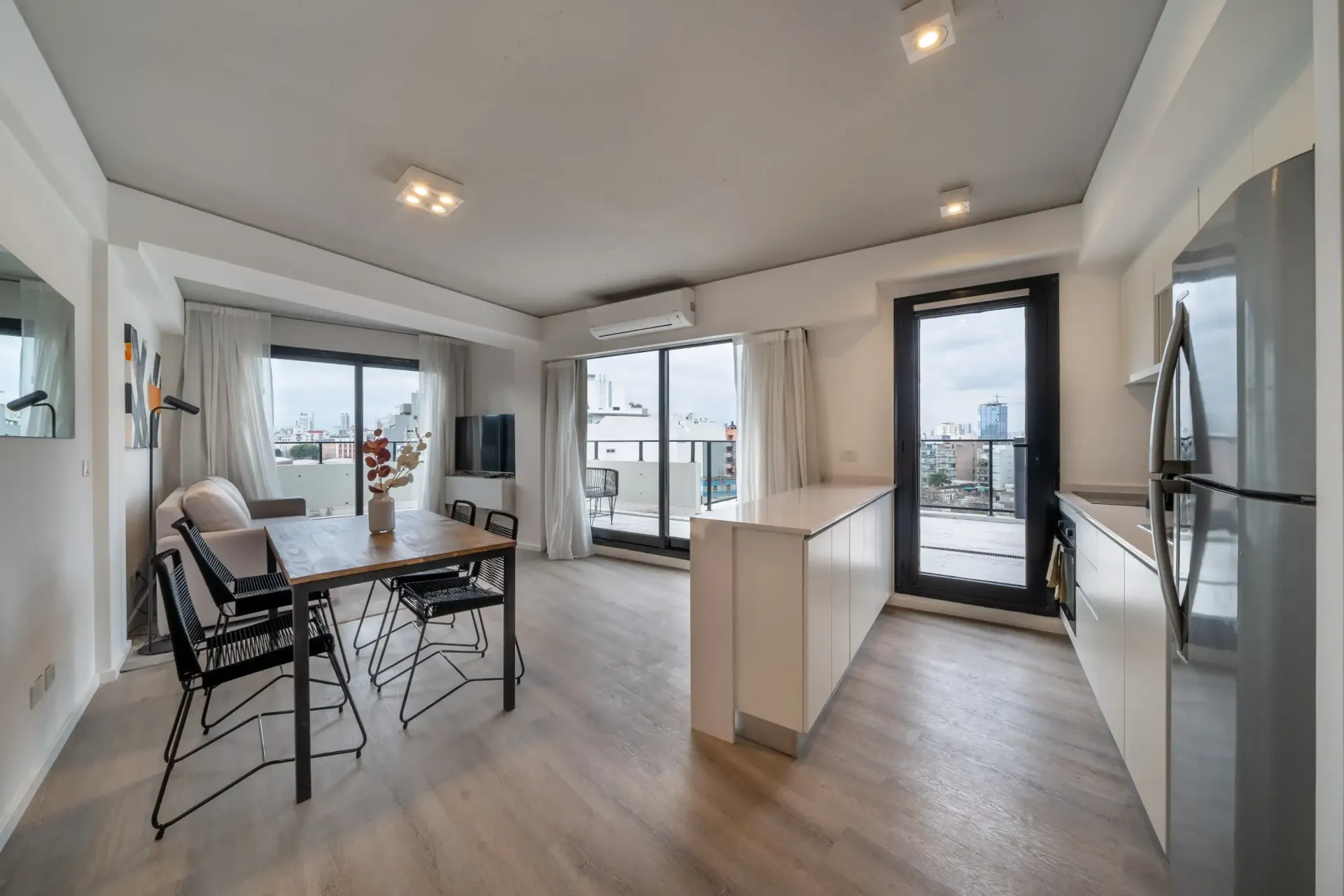 Una sala de estar con mesa y sillas y una cocina.