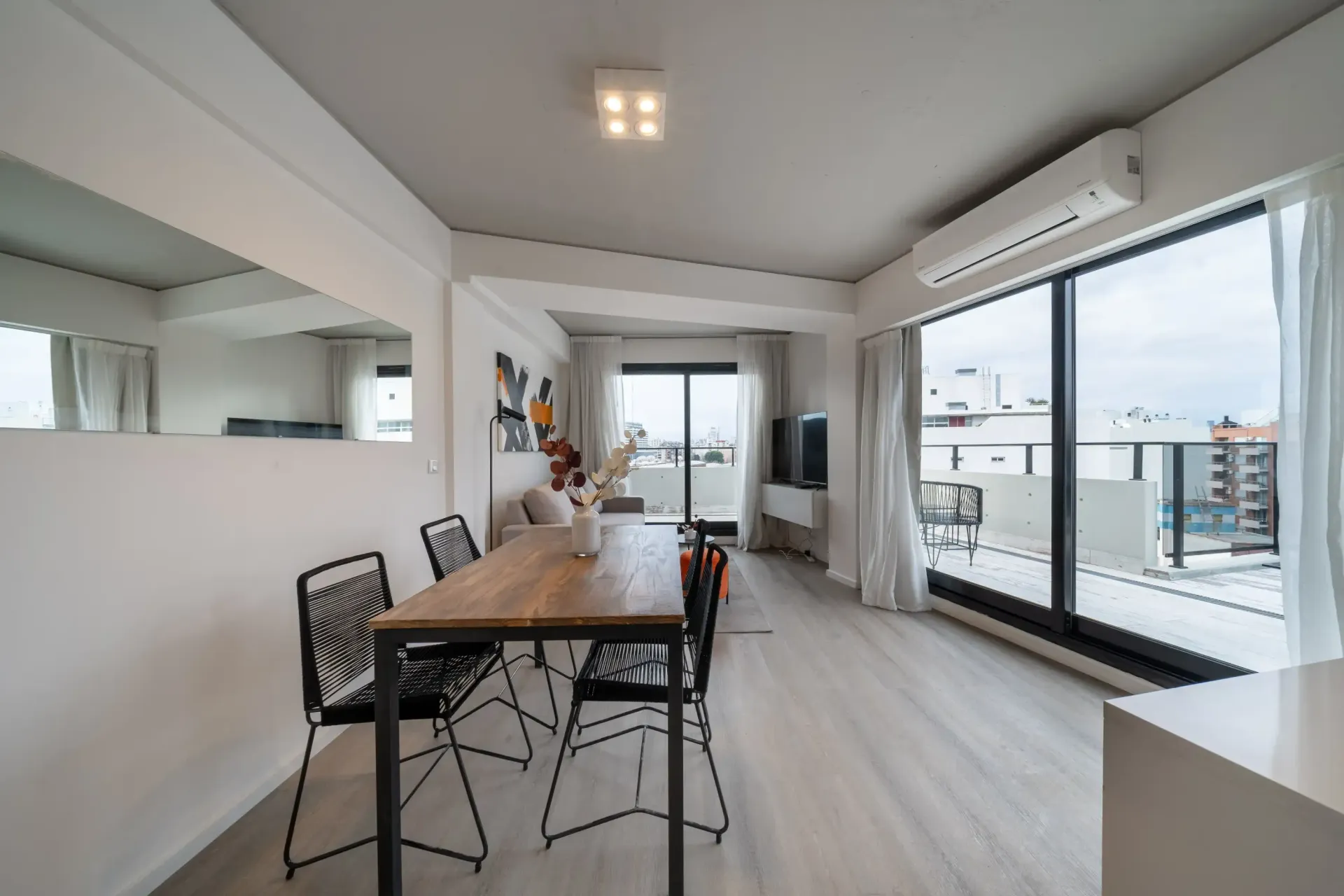 Una sala de estar con una mesa y sillas y una gran ventana.