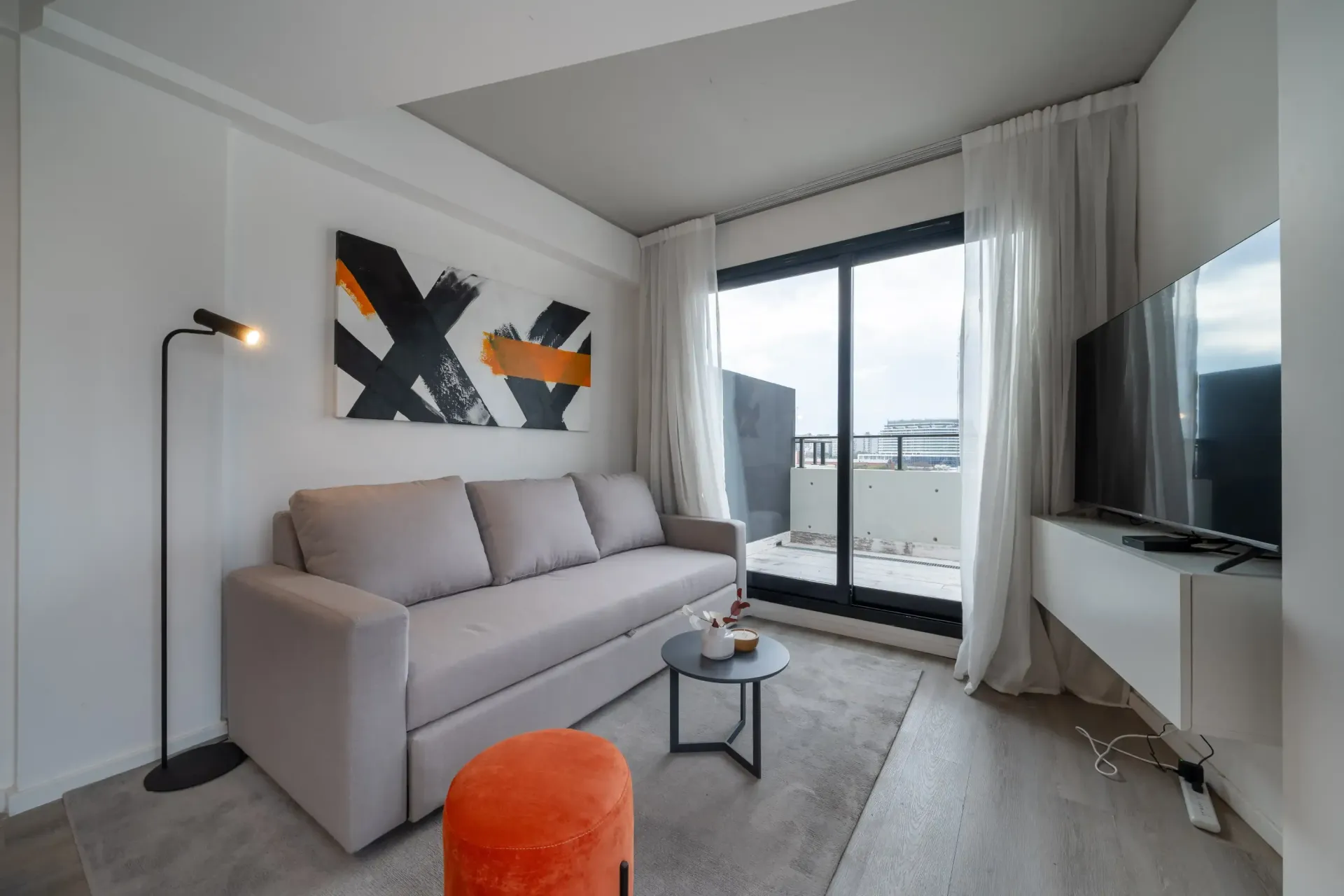 Una sala de estar con un sofá y una televisión.