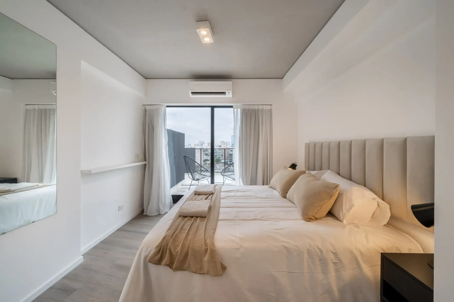Un dormitorio con una cama grande y una ventana grande.