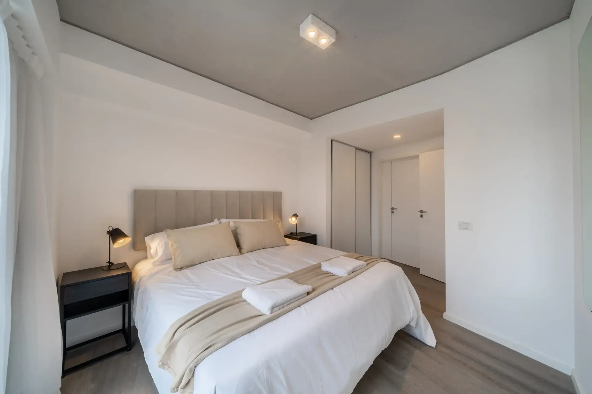Un dormitorio con una cama grande y dos mesitas de noche.