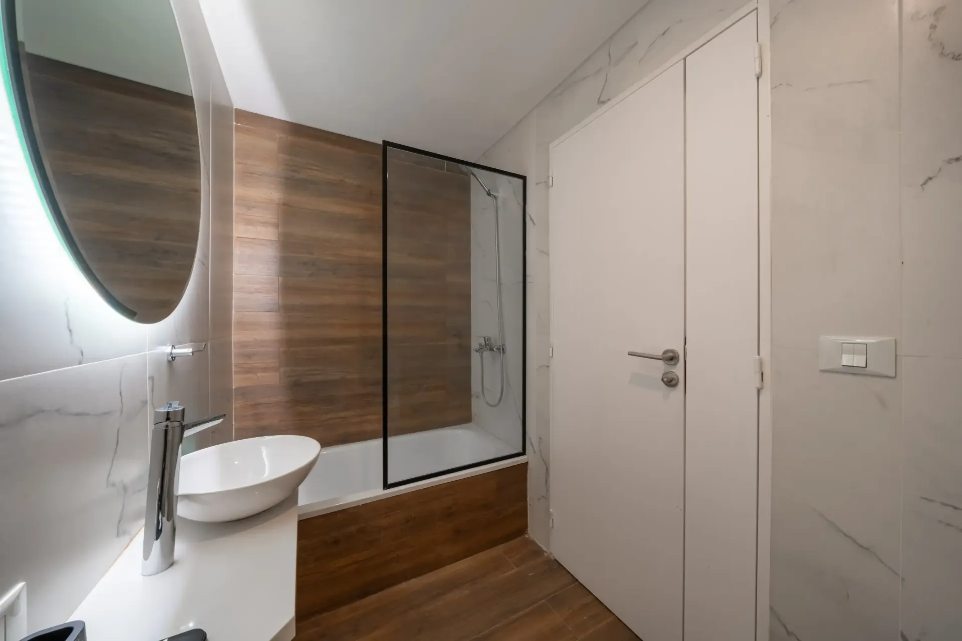 Un baño con lavabo, espejo, bañera y ducha.