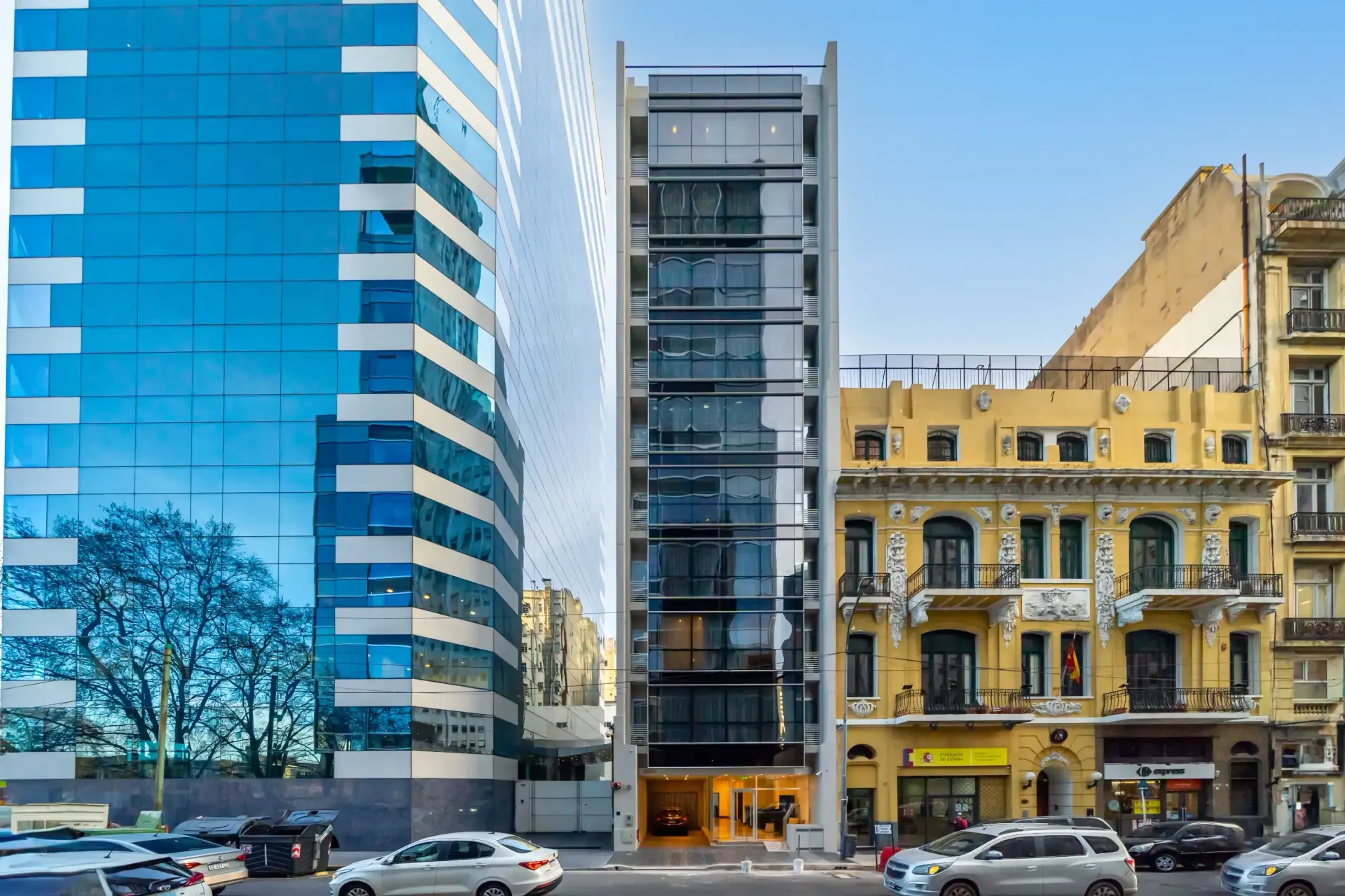 Un edificio con muchas ventanas está al lado de un edificio con muchas ventanas.