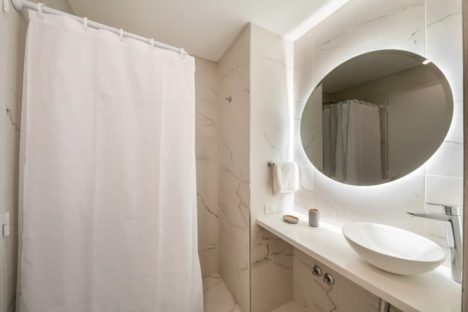 Un baño con lavabo, espejo y cortina de ducha.