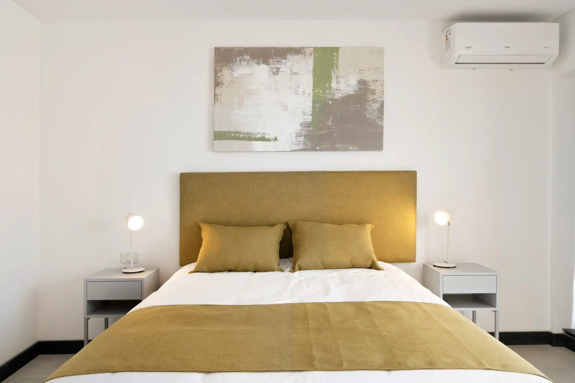 Un dormitorio con una cama y un cuadro en la pared.