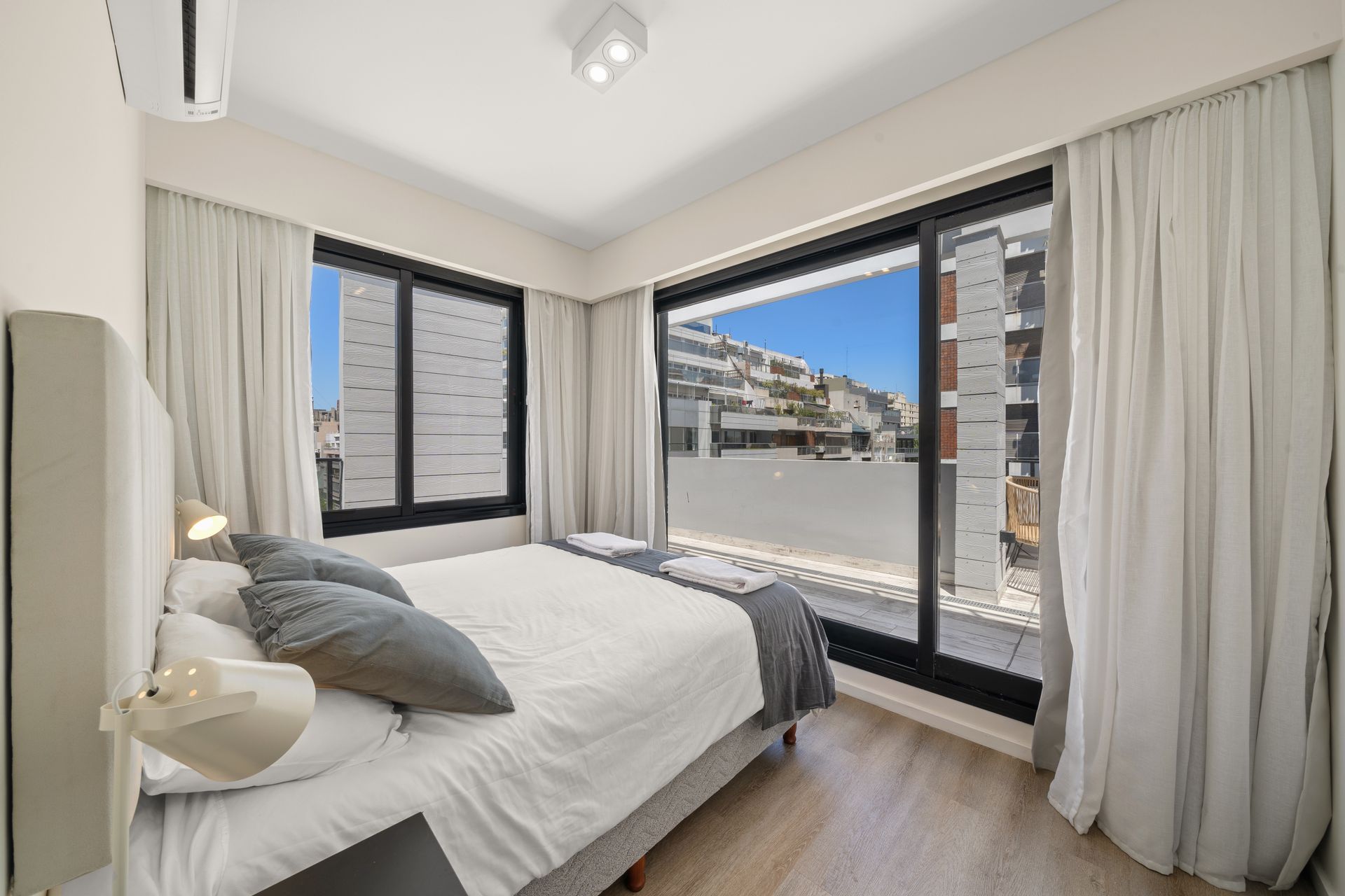Un dormitorio con una cama king size y puertas corredizas de vidrio.