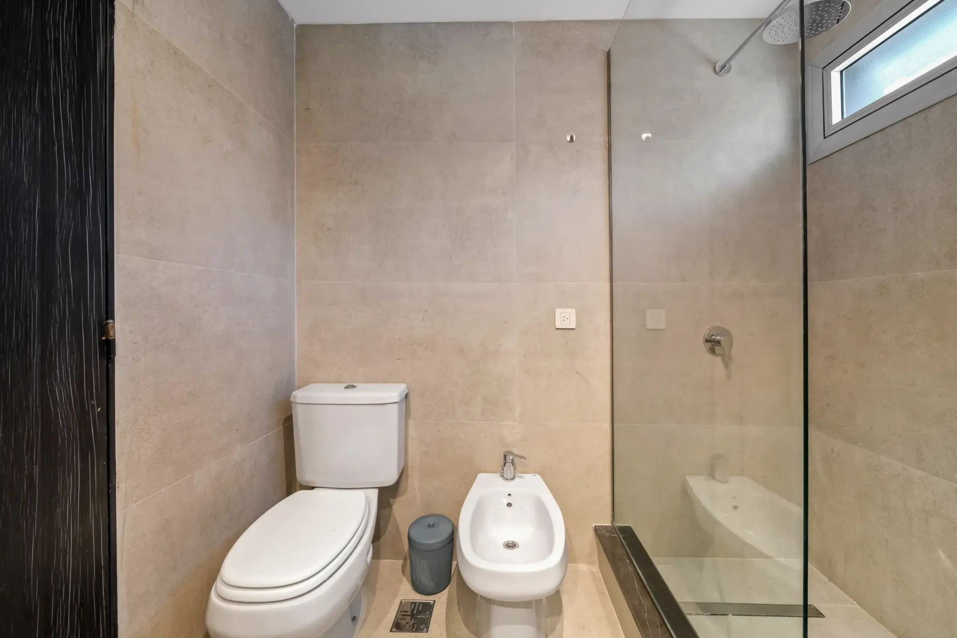 Un baño con inodoro, bidé y ducha.