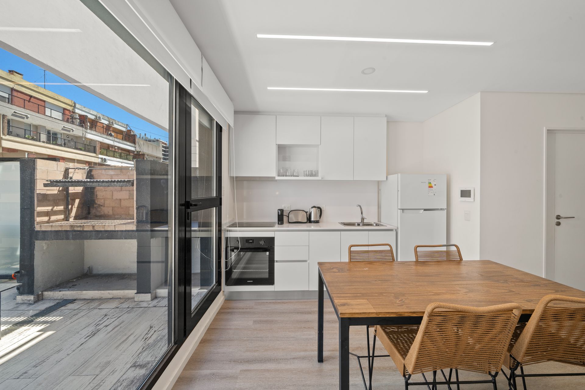 Una cocina con mesa y sillas y una gran ventana.