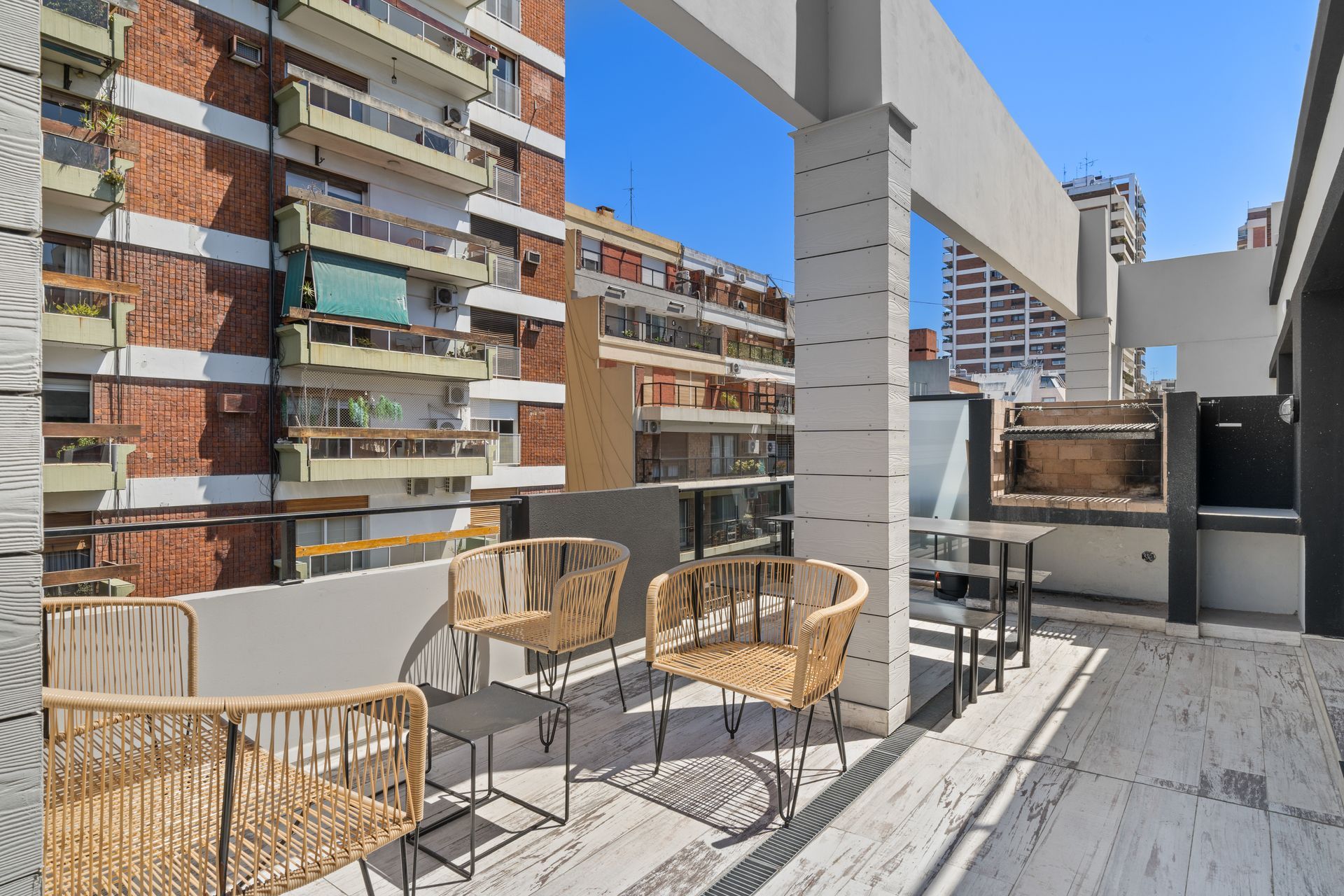 Un balcón con sillas y una mesa frente a un edificio.