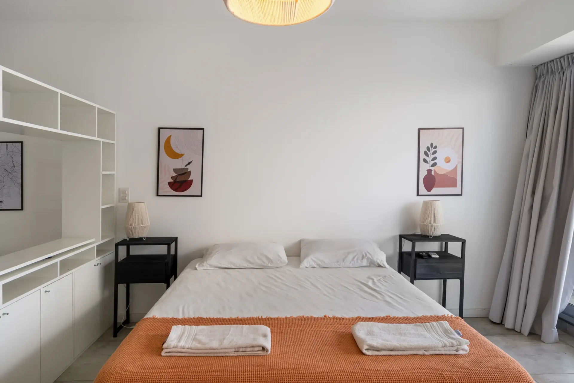 Un dormitorio con una cama grande y dos mesitas de noche.