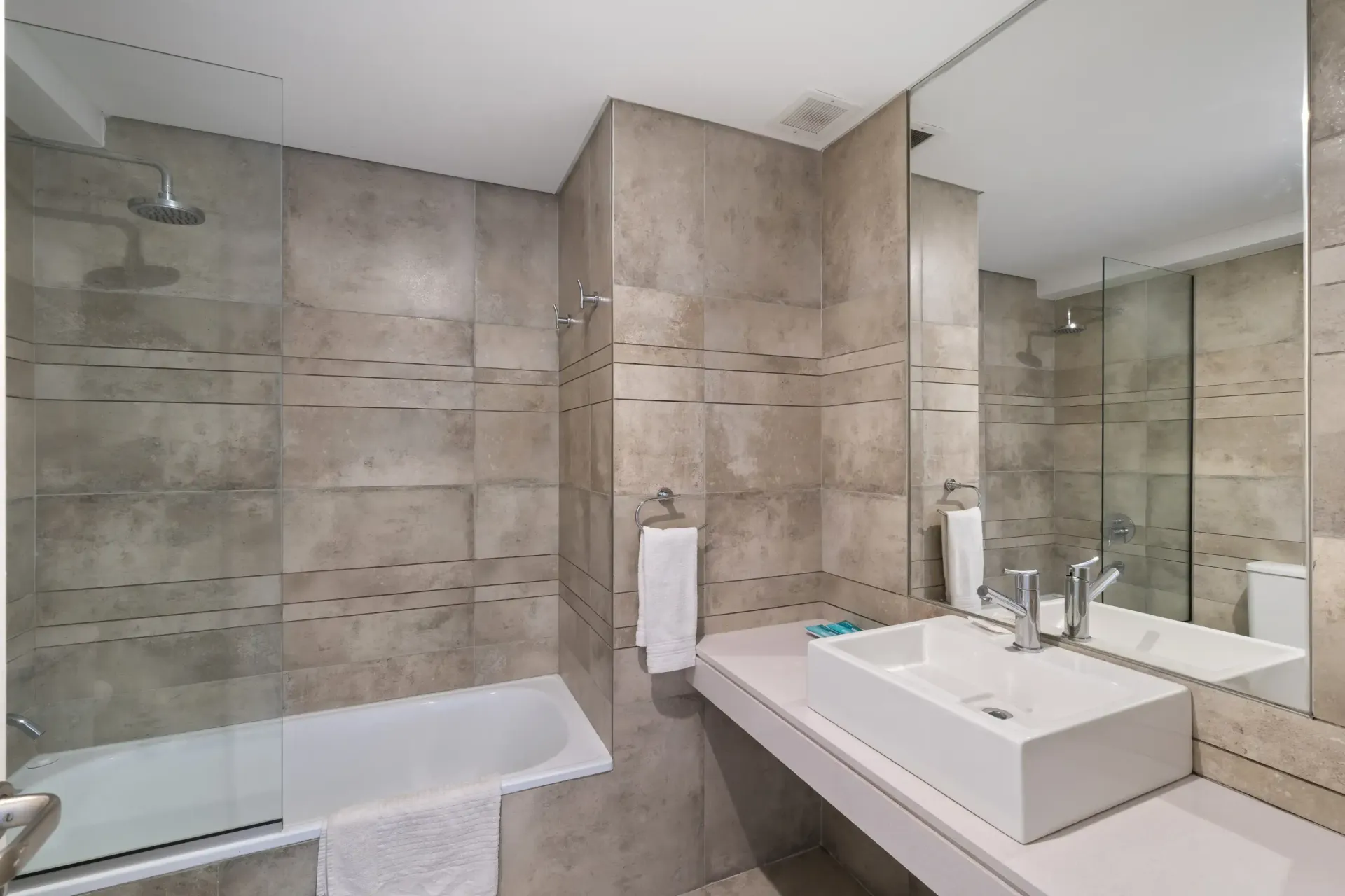 Un baño con lavabo, bañera, espejo y ducha.