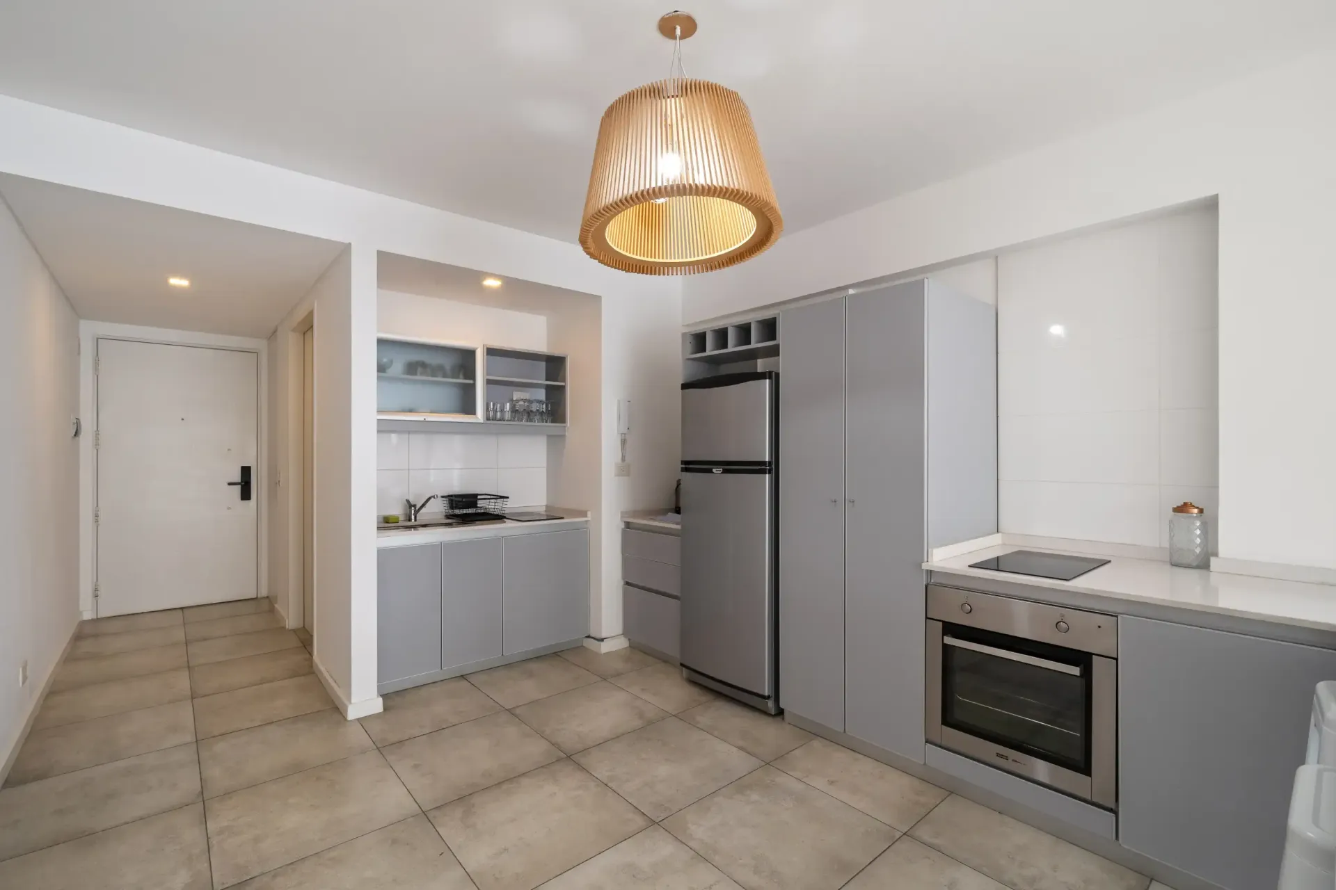Una cocina con electrodomésticos de acero inoxidable, refrigerador y estufa.