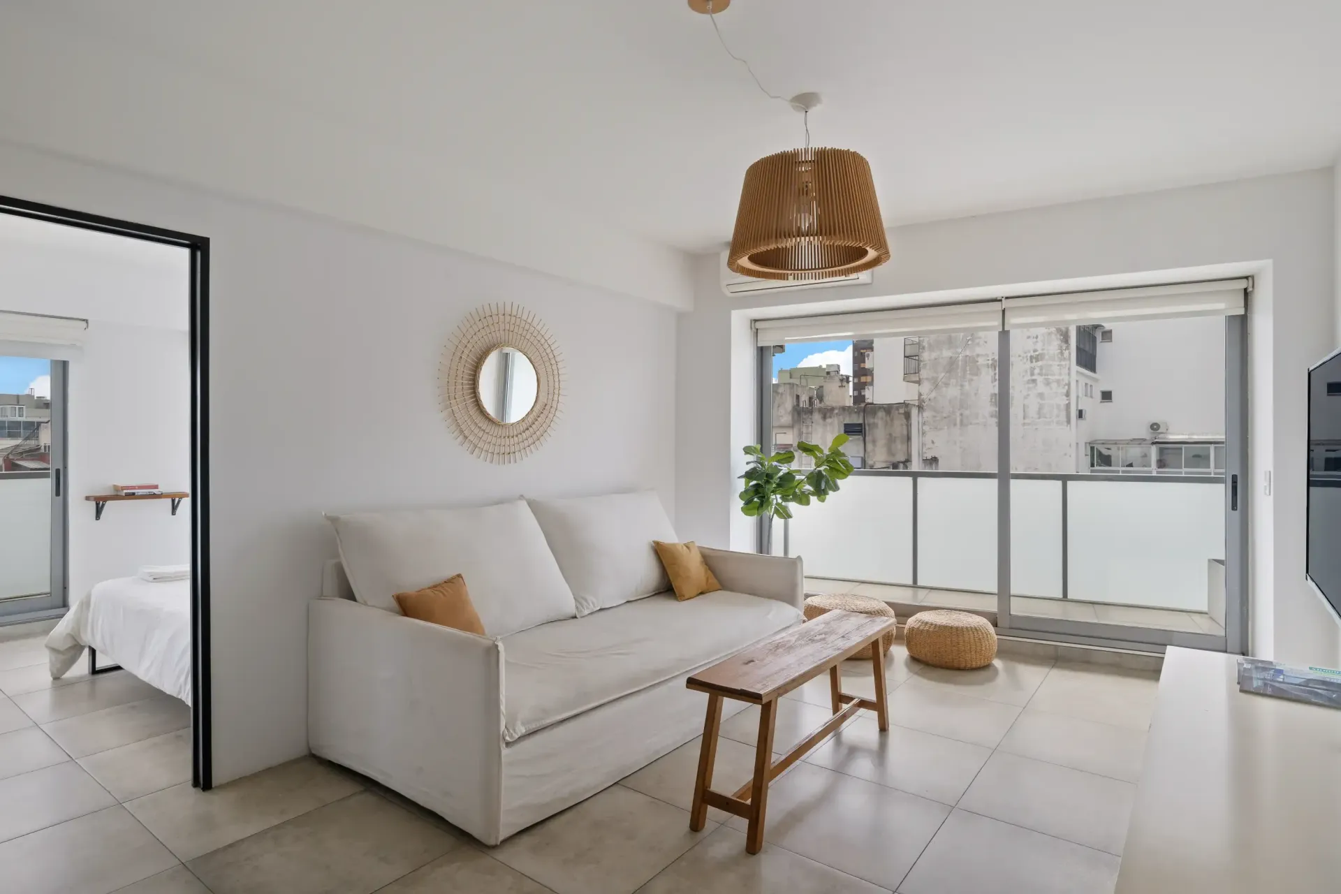 Una sala de estar con un sofá blanco y una mesa de madera.