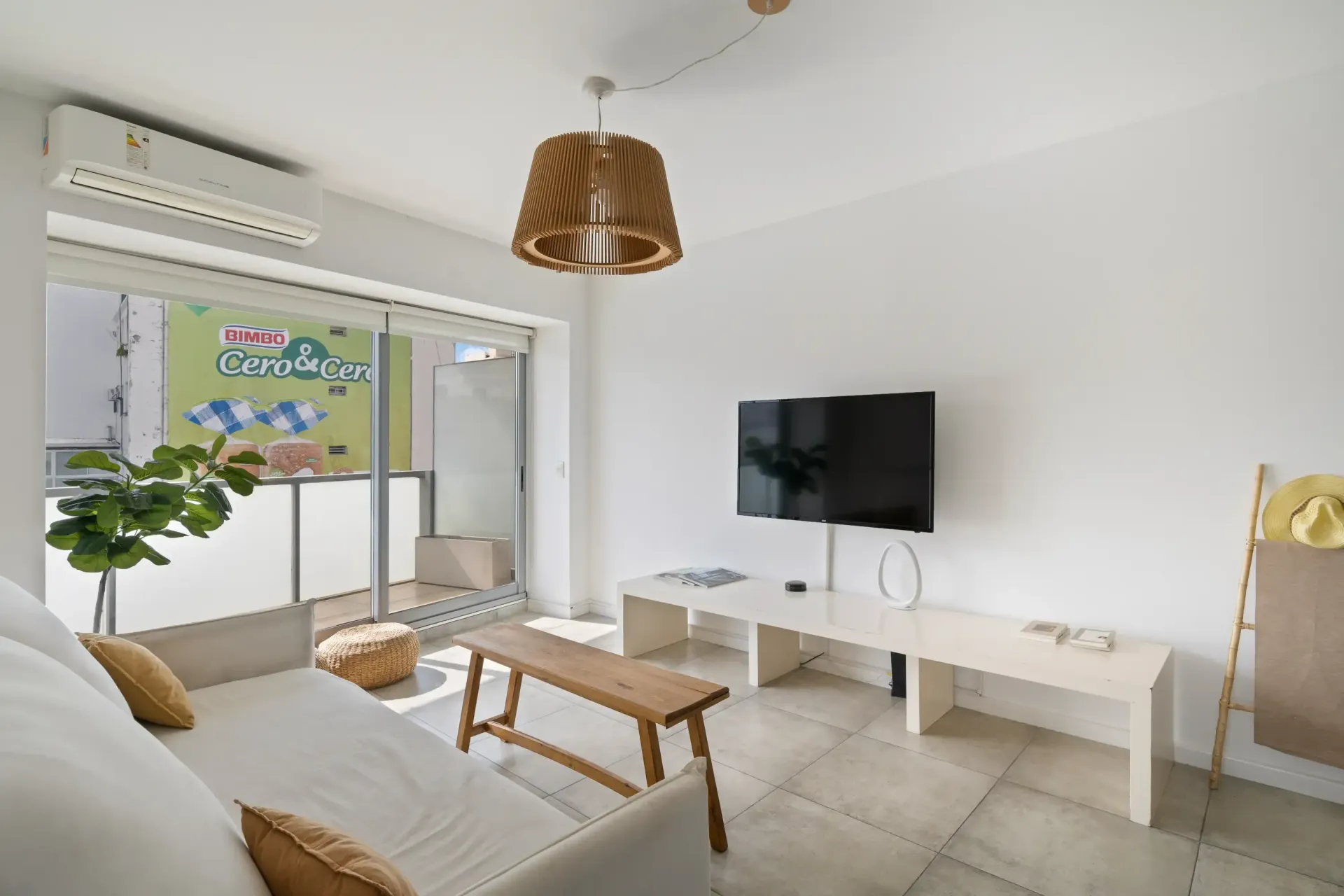 Una sala de estar con sofá, mesa y televisión.