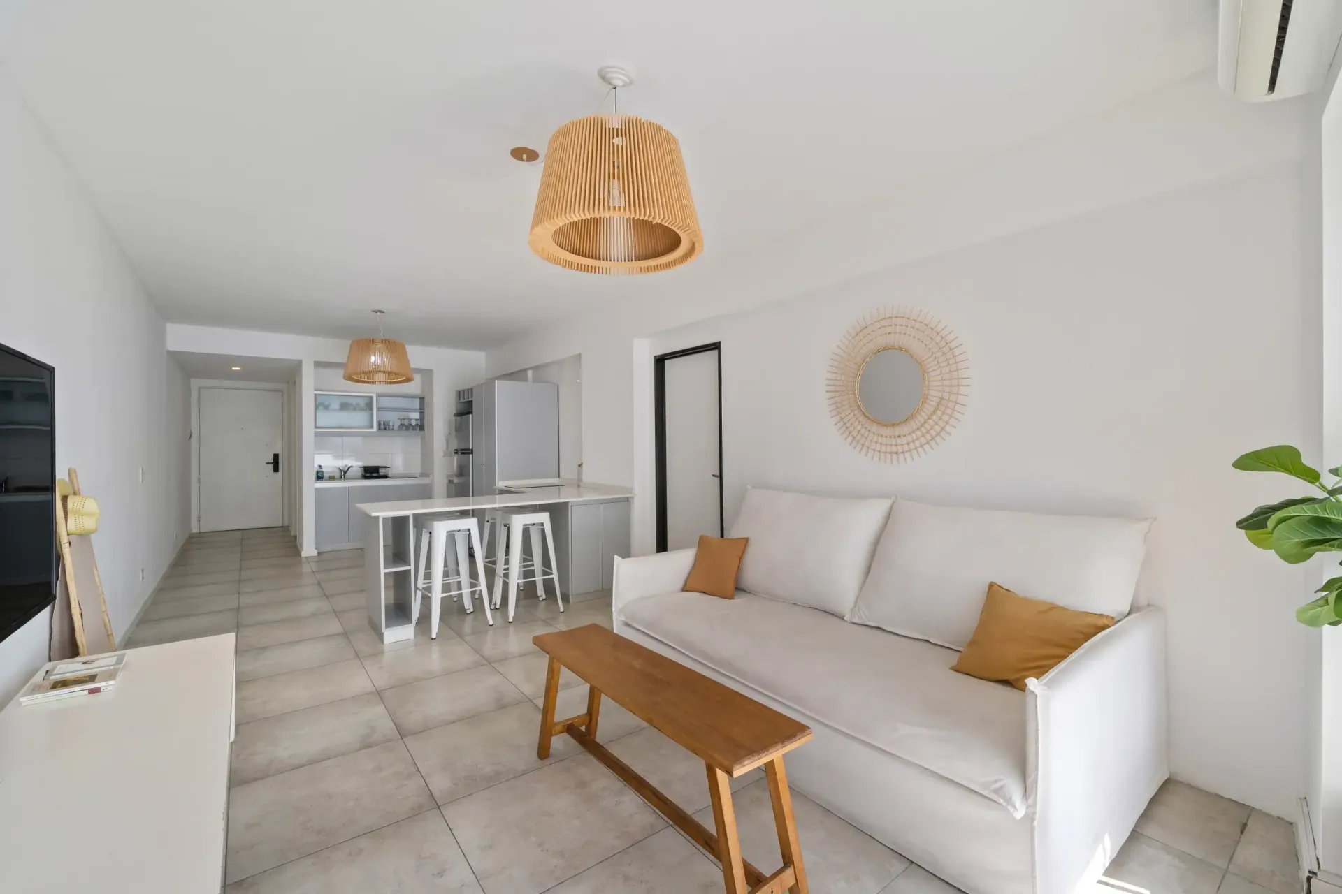 Una sala de estar con sofá, mesa y televisión.