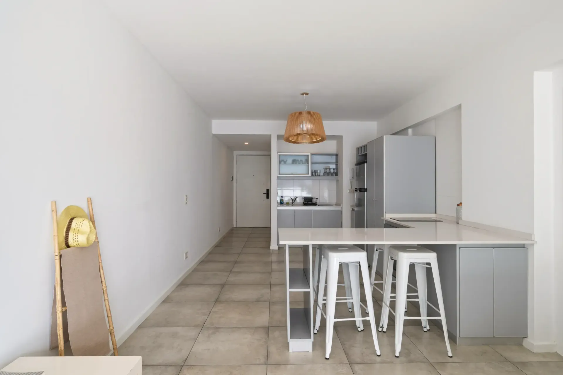 Una cocina con taburetes y un refrigerador en ella.