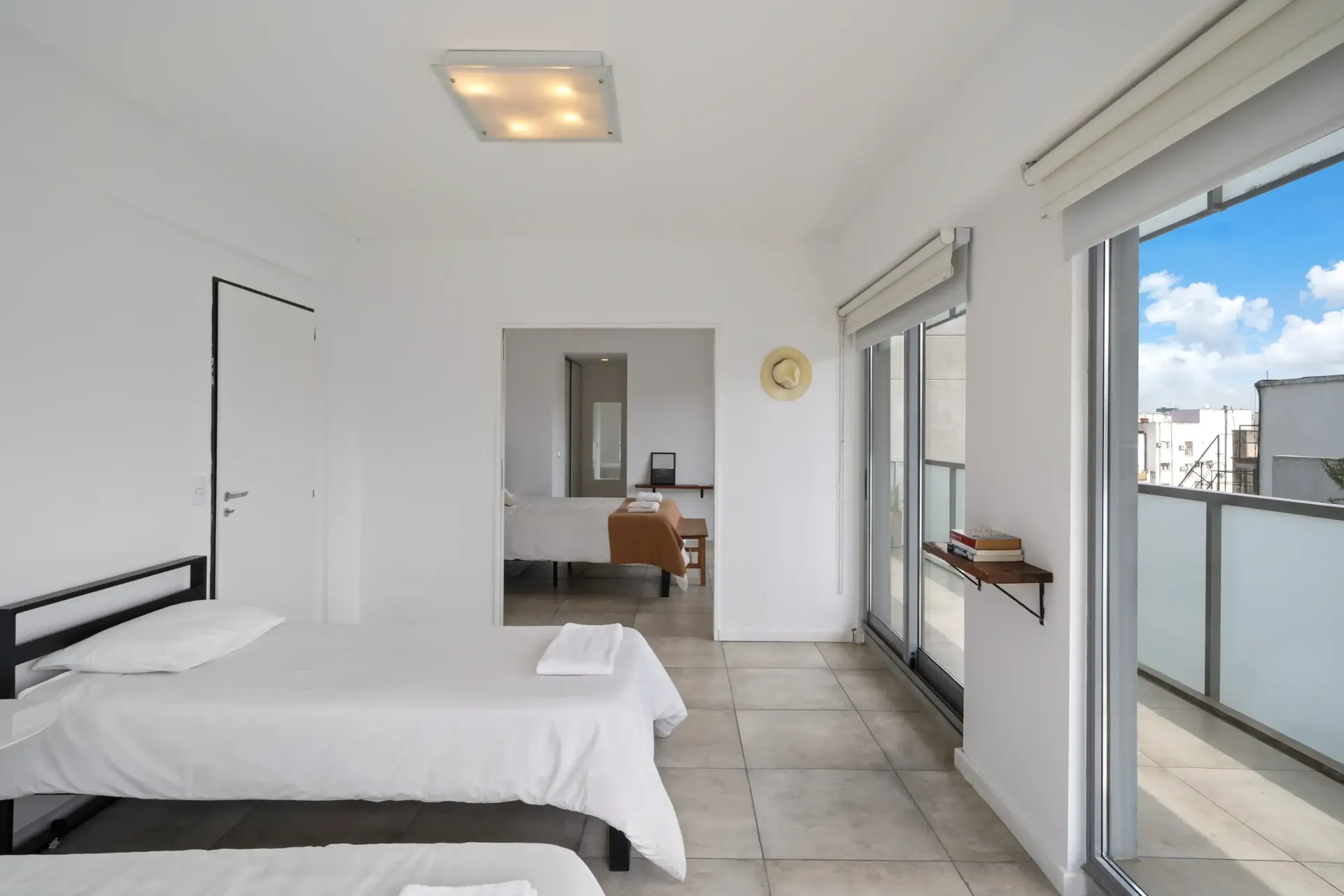 Un dormitorio con dos camas y un balcón con vista a la ciudad.
