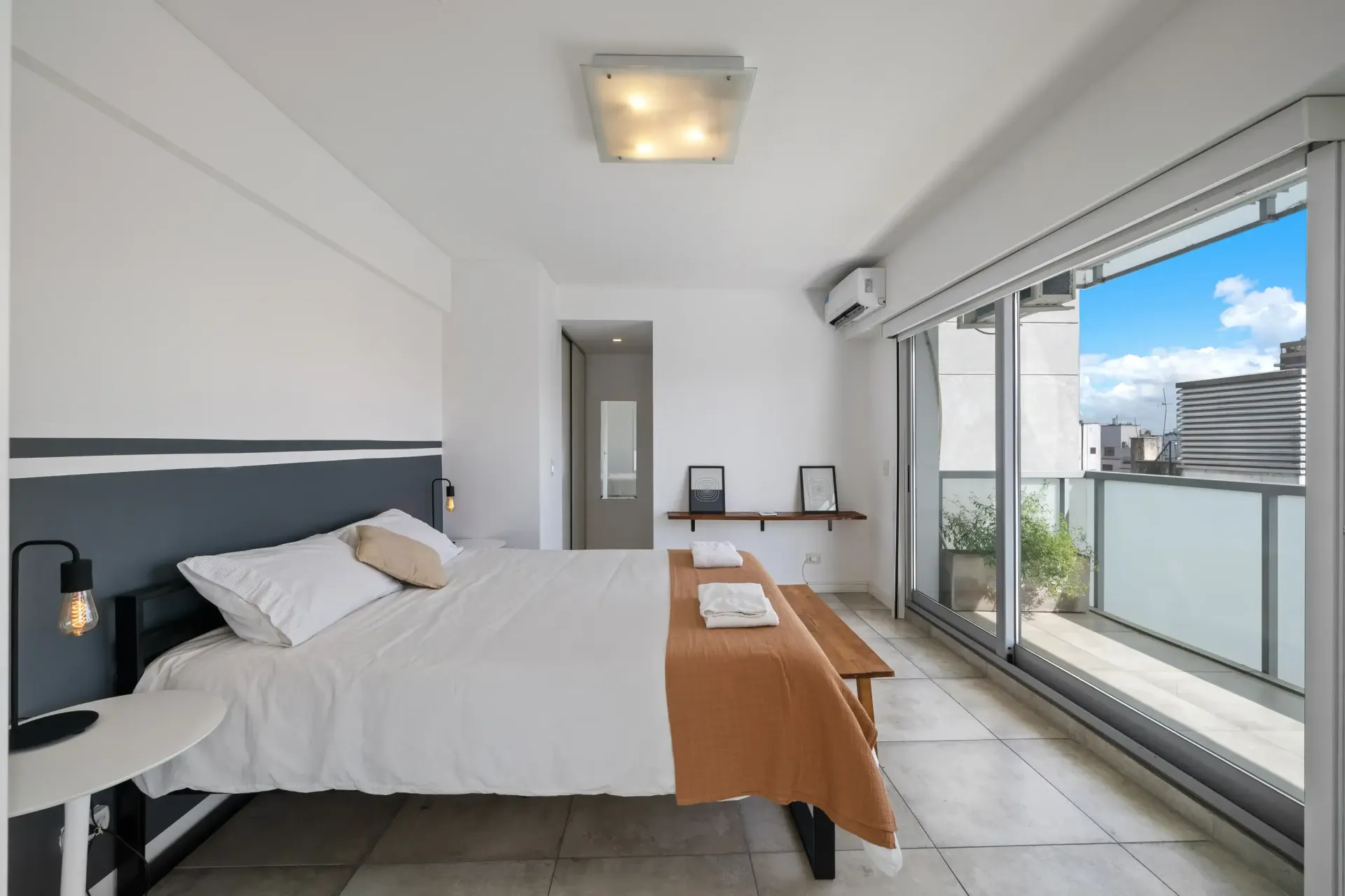 Un dormitorio con una cama grande y un balcón.