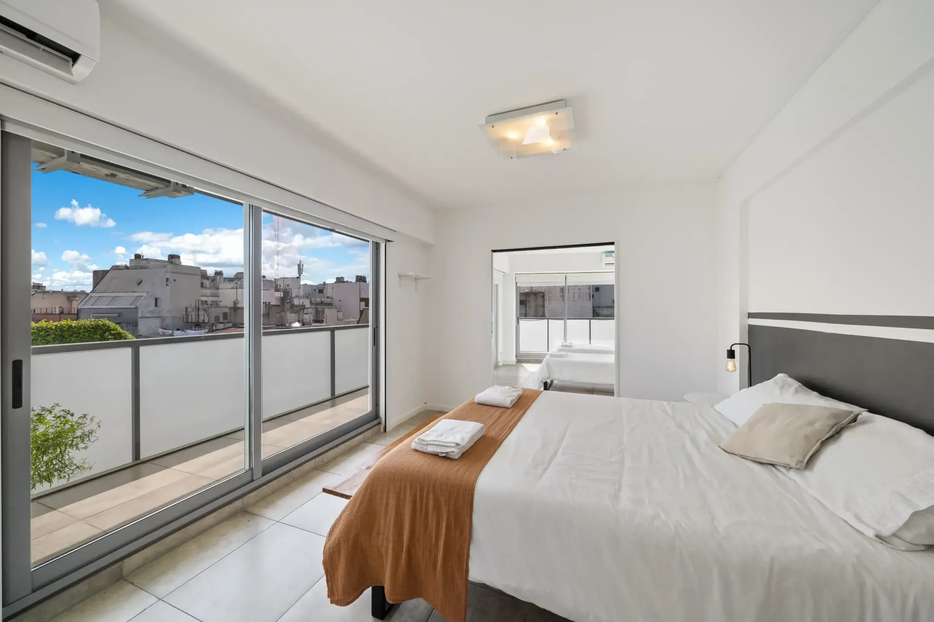 Un dormitorio con una cama grande y puertas corredizas de vidrio.