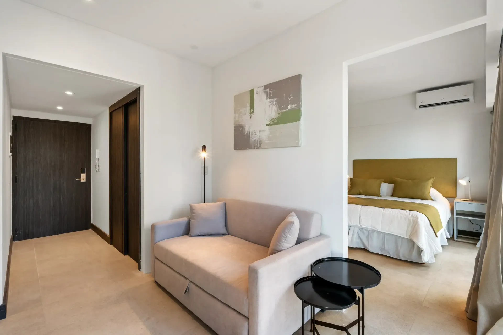 Una habitación de hotel con un sofá y una cama.