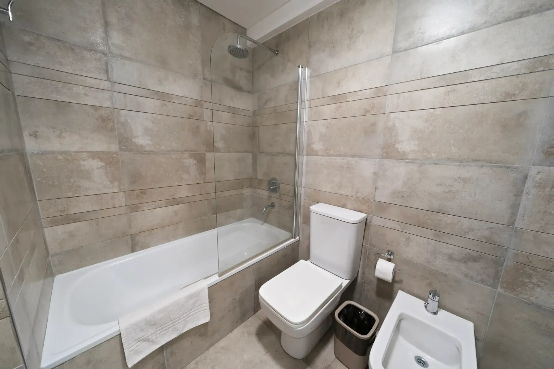 Un cuarto de baño con inodoro, lavabo, bañera y ducha.