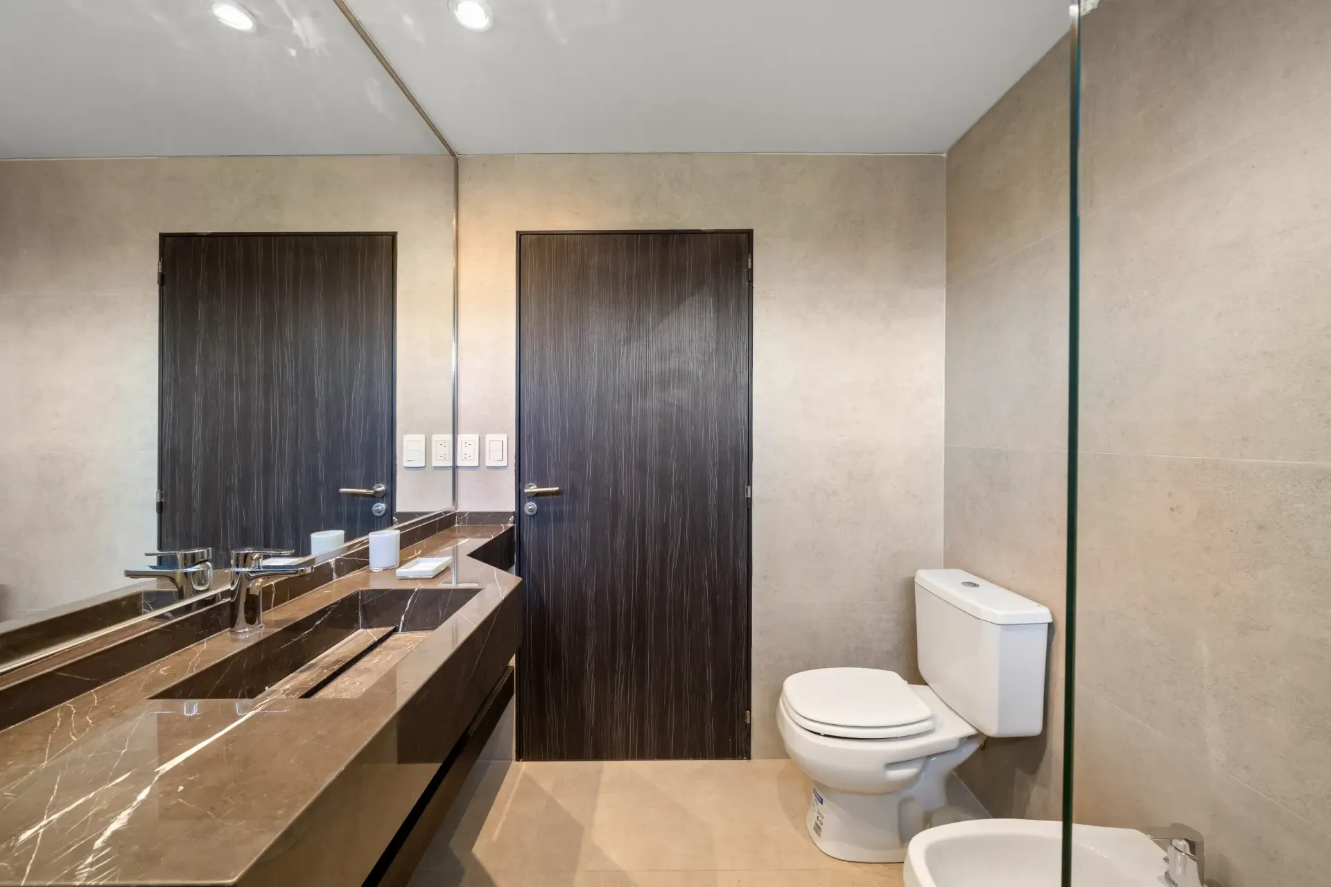 Un baño con inodoro, lavabo y espejo.