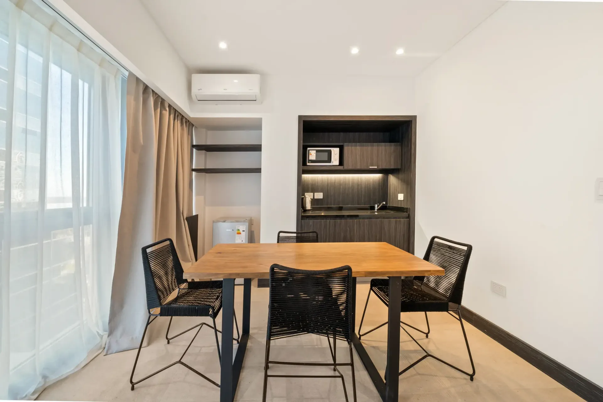 Un comedor con mesa y sillas de madera.