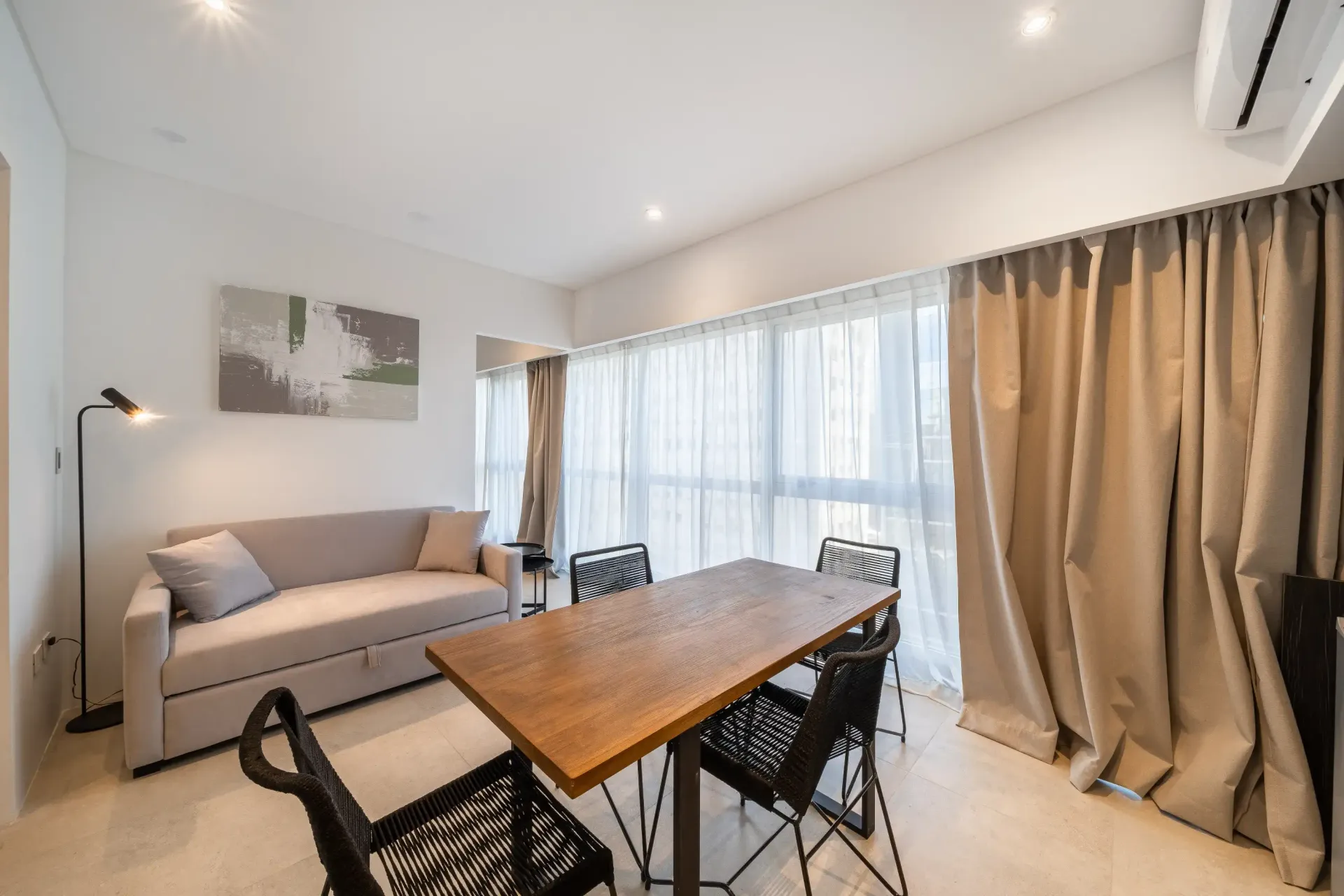 Una sala de estar con sofá, mesa y sillas.