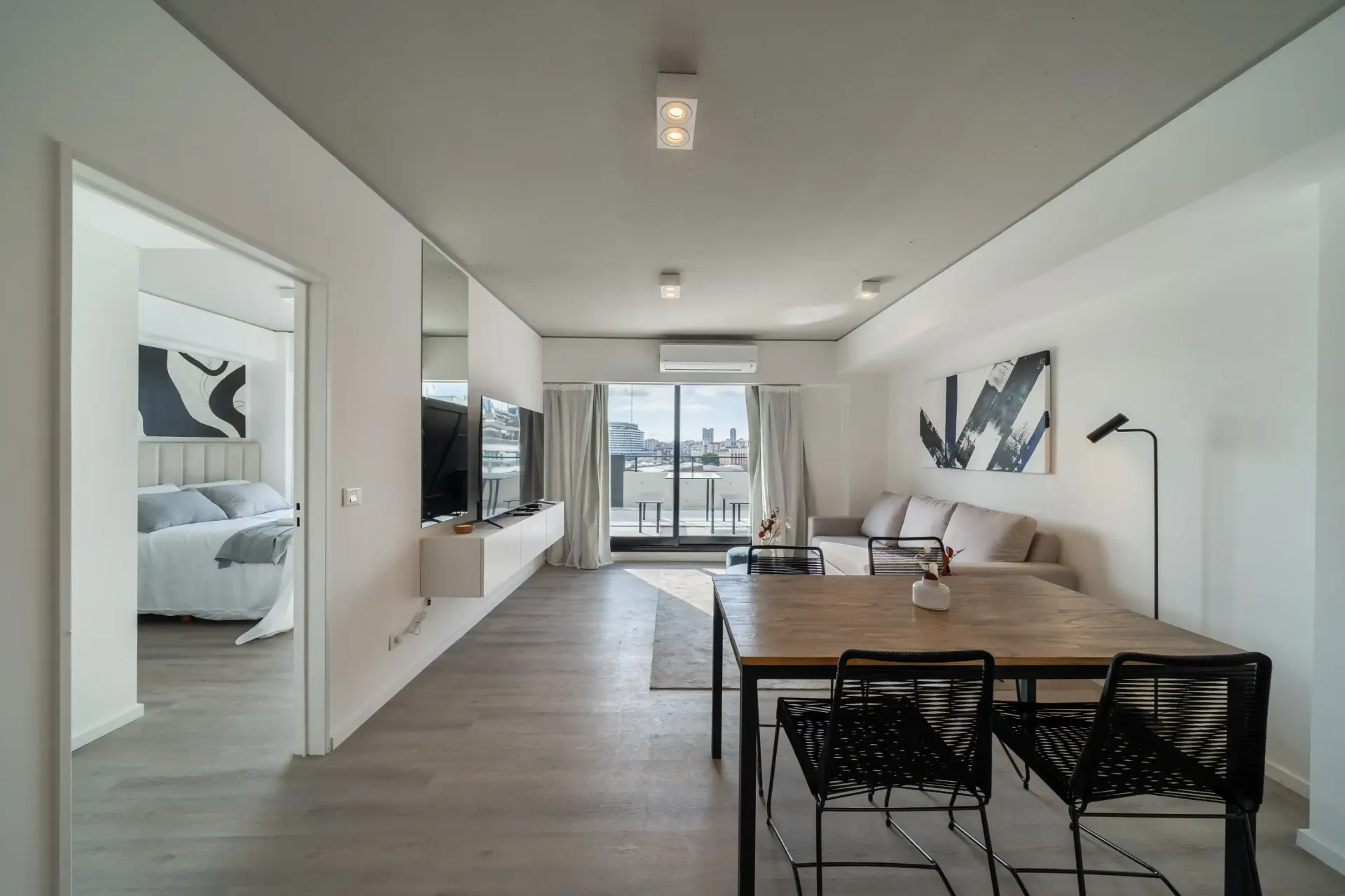 Una sala de estar con una mesa de comedor y sillas y un sofá.