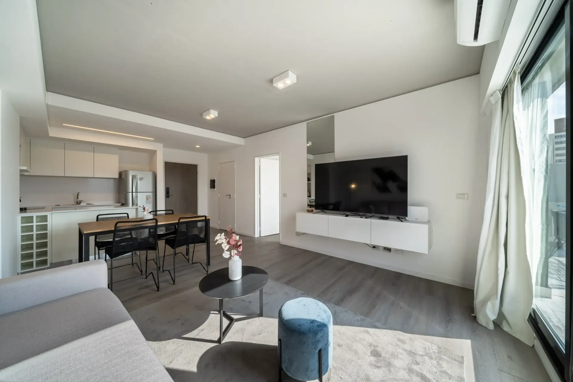 Una sala de estar con sofá, mesa y televisión.