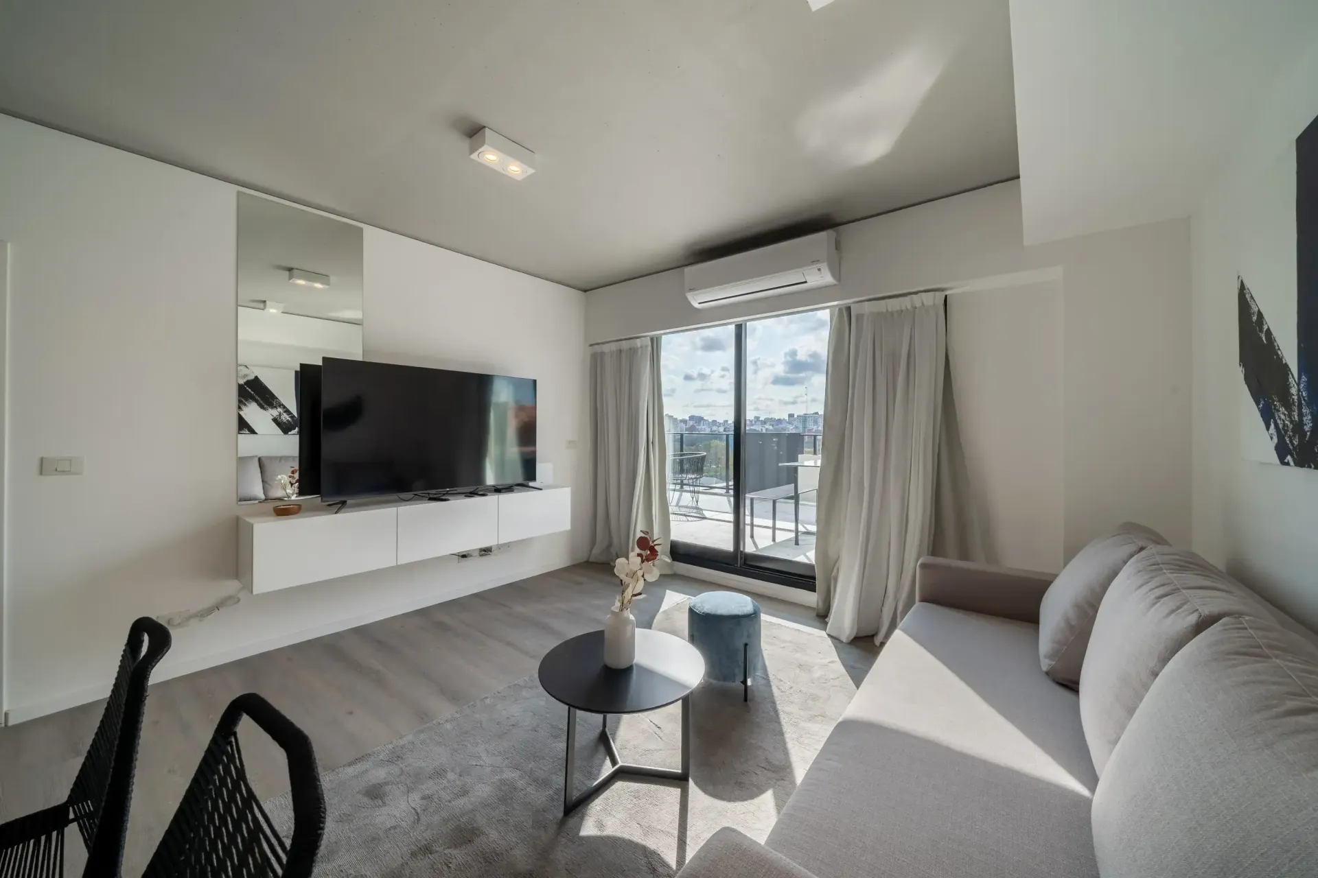 Una sala de estar con sofá, mesa y televisión.