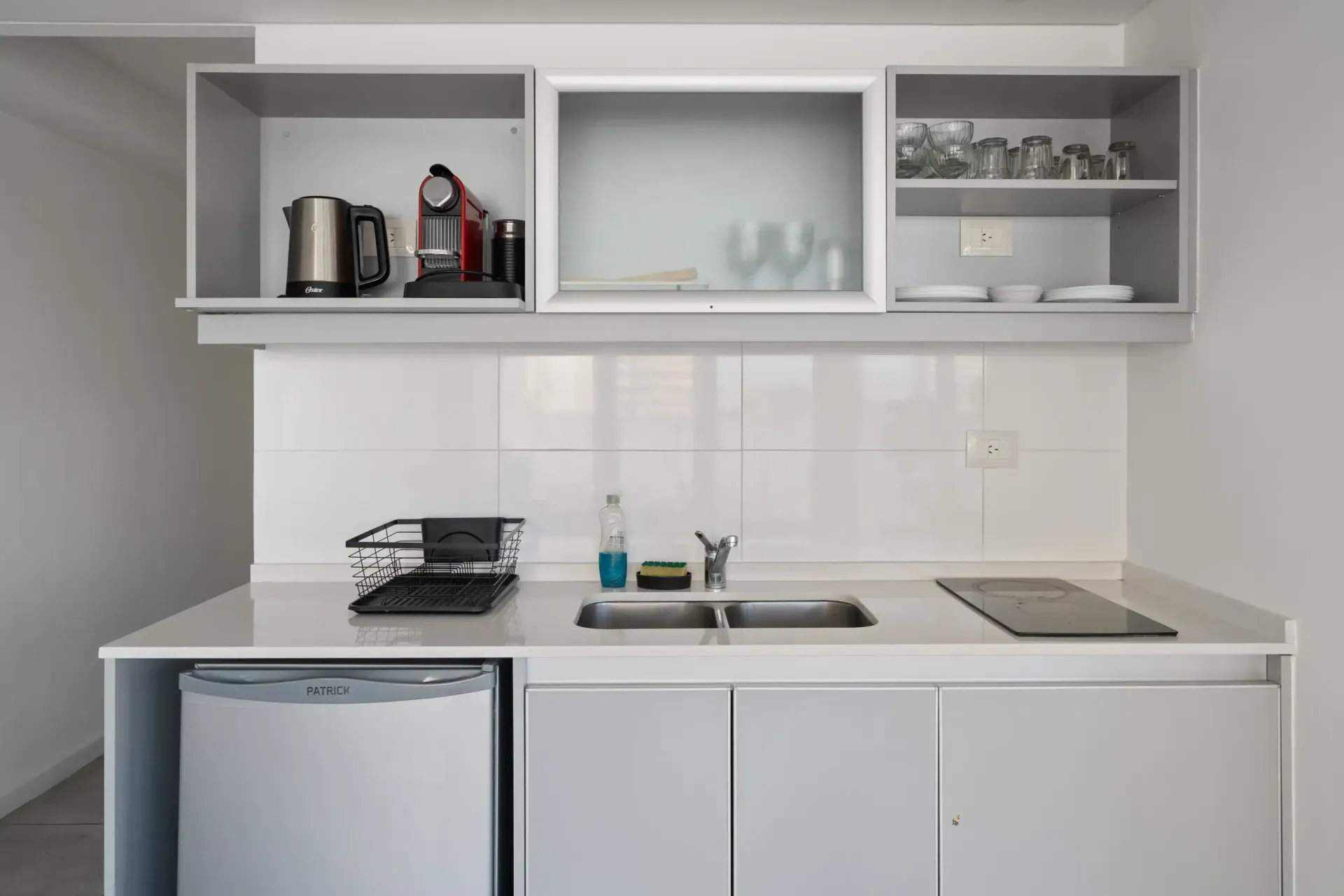 Una cocina con gabinetes blancos y un fregadero.