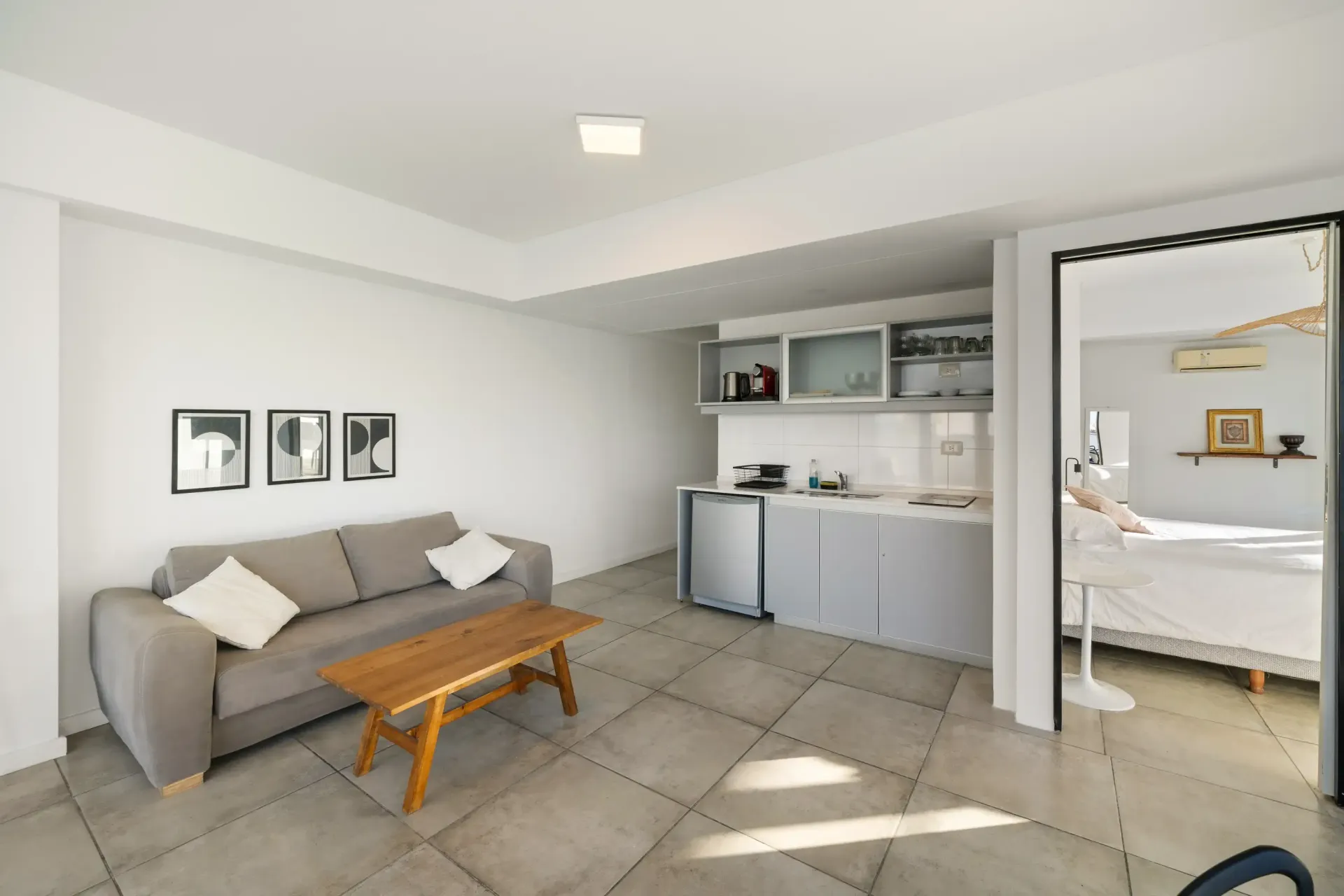 Una sala de estar con sofá, mesa de café y cocina.