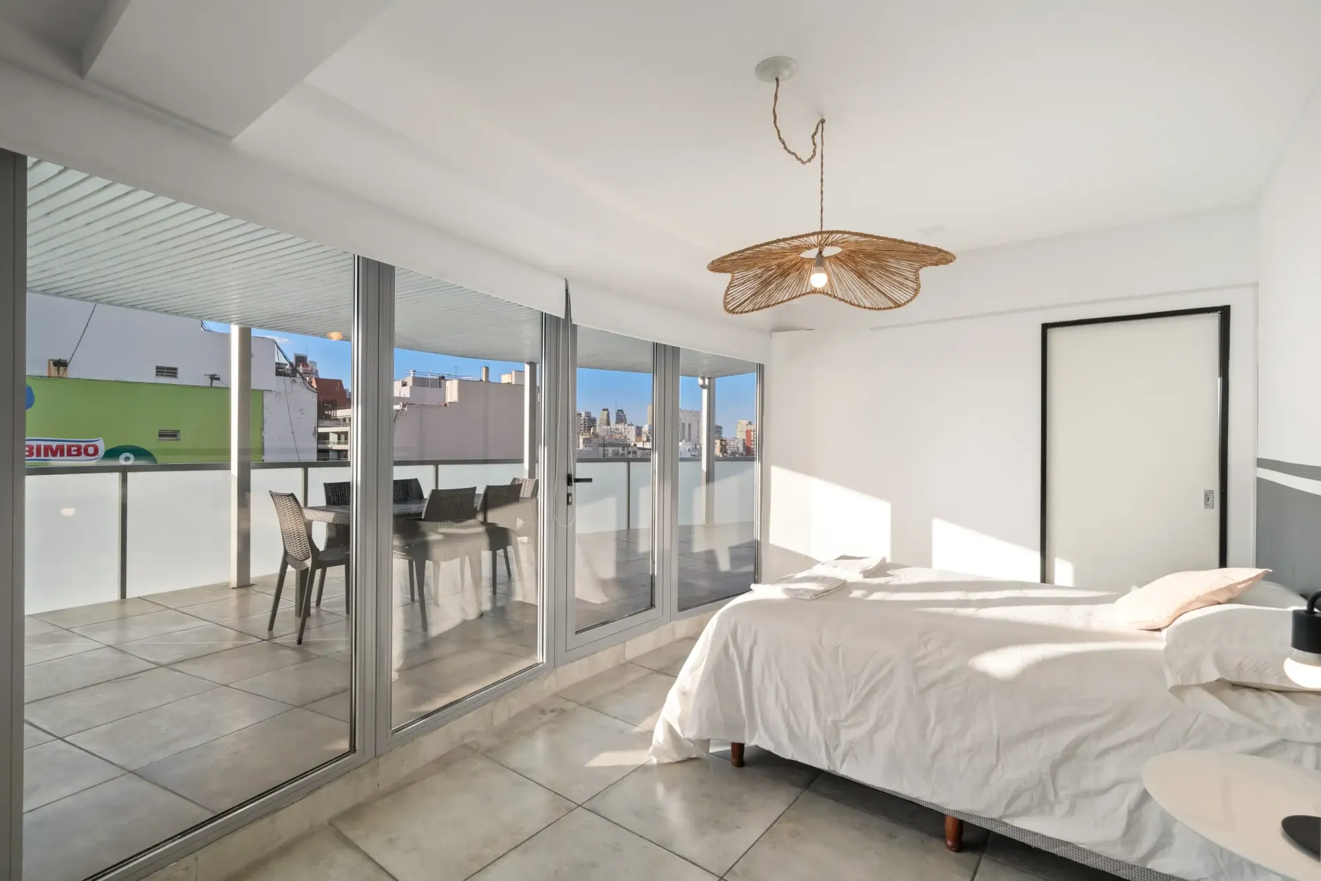 Un dormitorio con una cama grande y muchas ventanas.