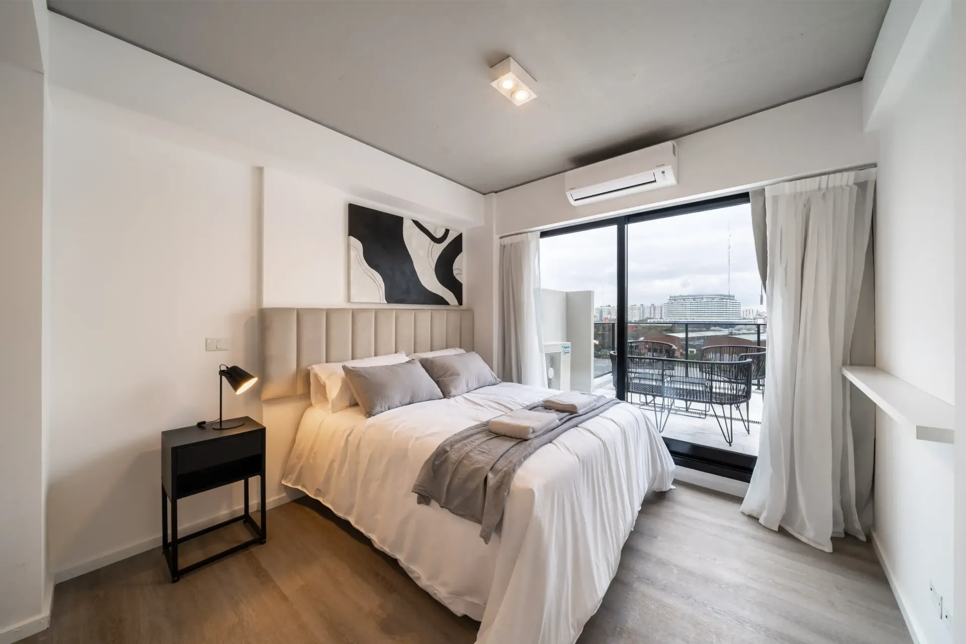 Un dormitorio con una cama grande y un balcón.