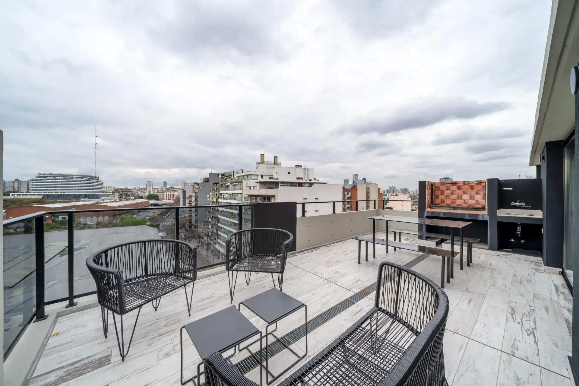 Un balcón con una mesa y sillas con vista a la ciudad.