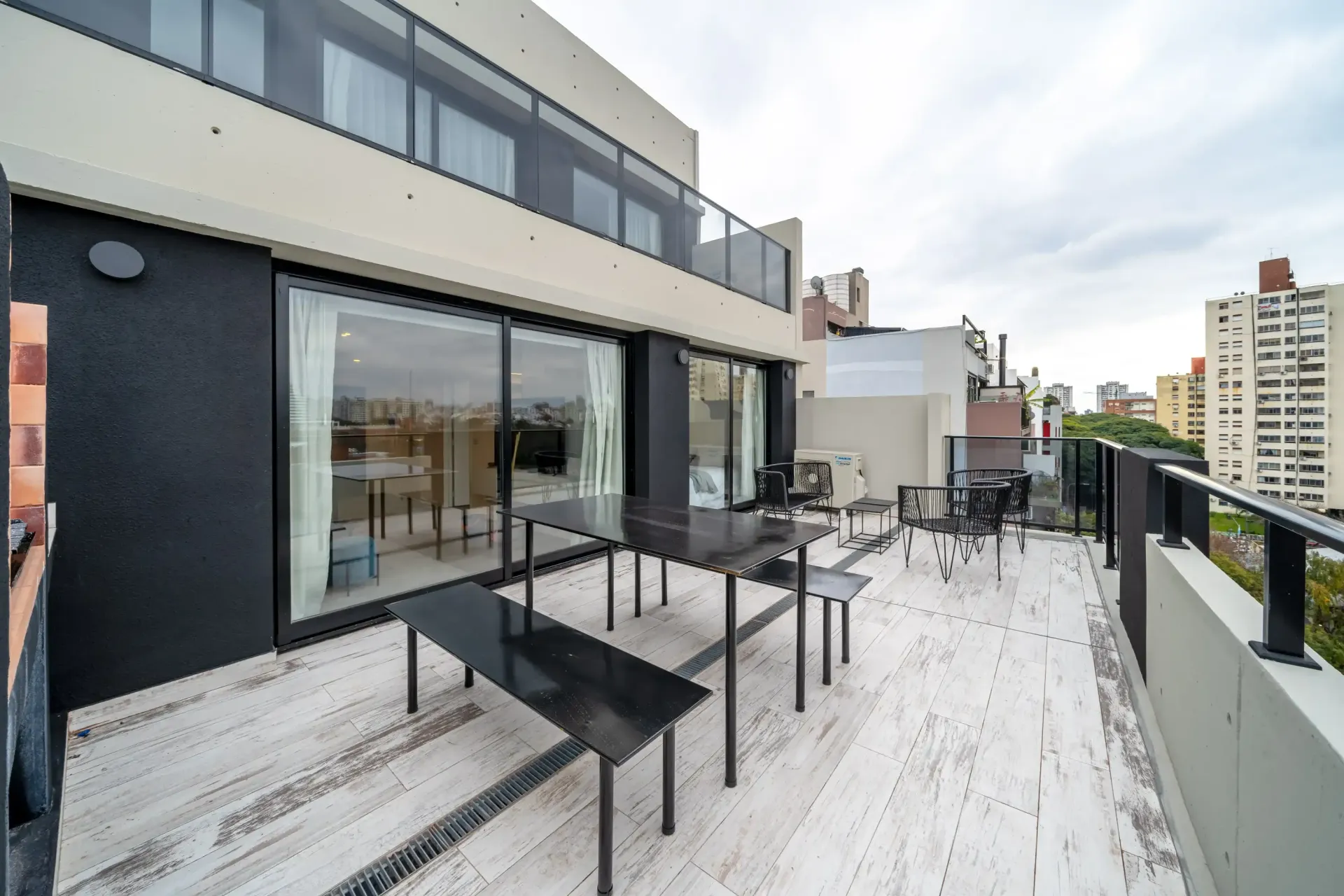 Una terraza en la azotea con una mesa y sillas.