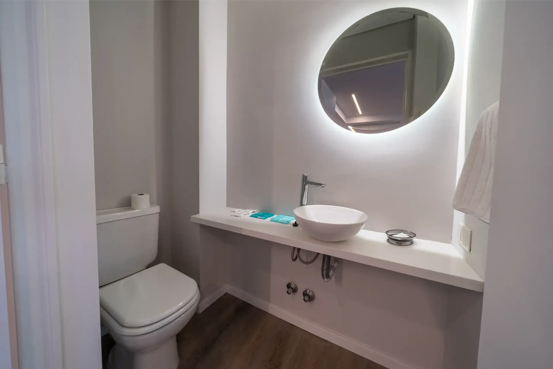 Un baño con inodoro, lavabo y espejo.