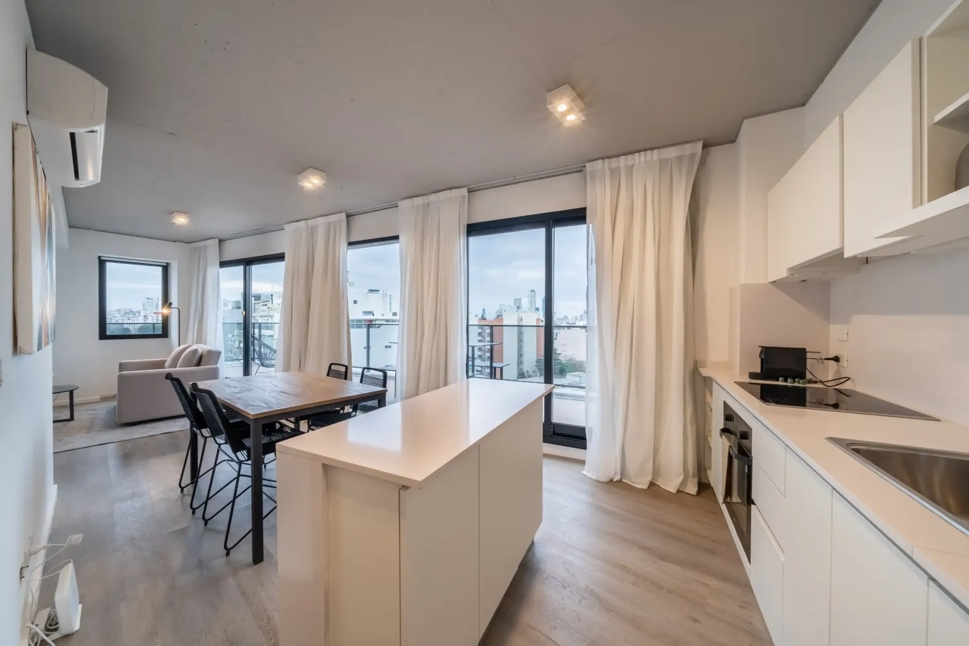 Una cocina con gabinetes blancos y una gran isla en el medio de la habitación.