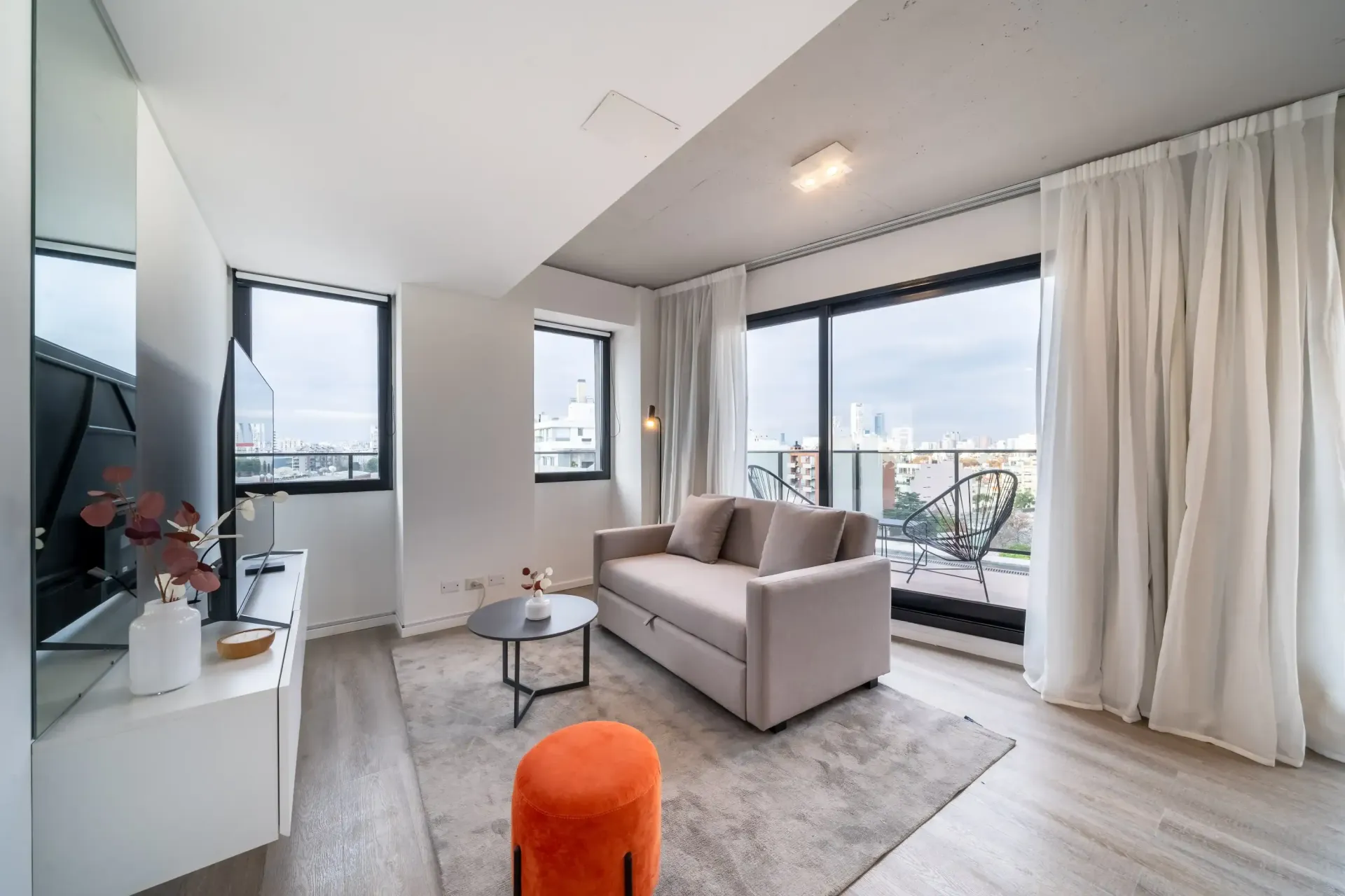 Una sala de estar con sofá, mesa y televisión.