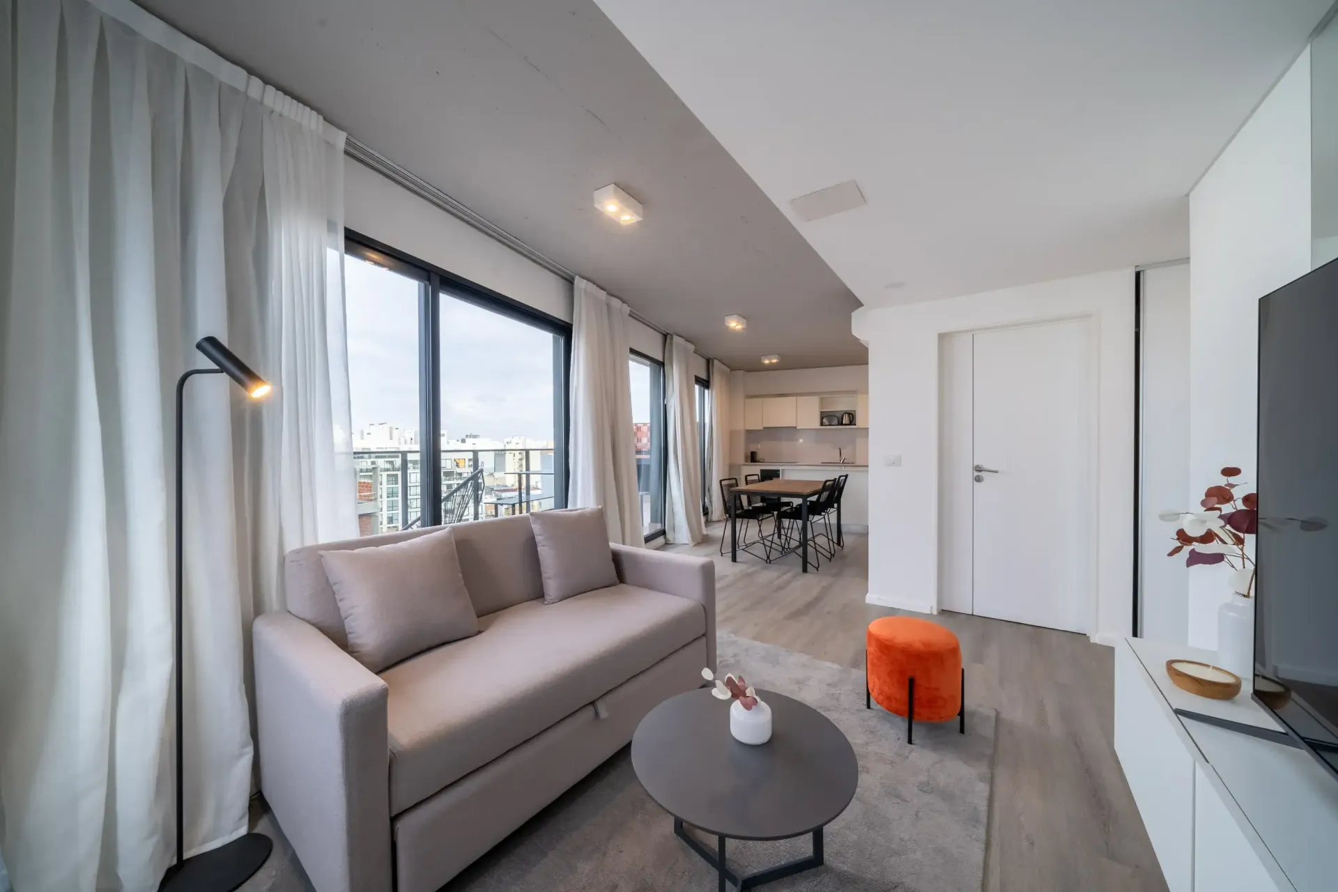 Una sala de estar con sofá, mesa y televisión.