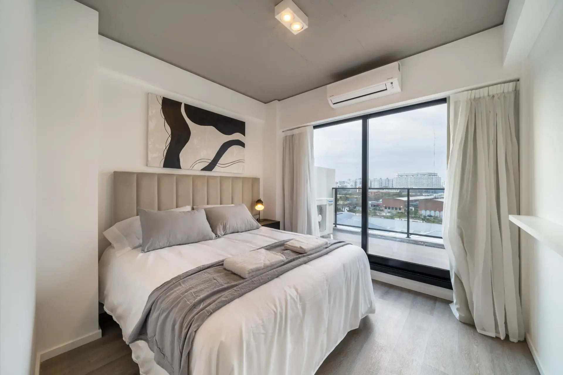 Un dormitorio con una cama grande y una ventana grande.