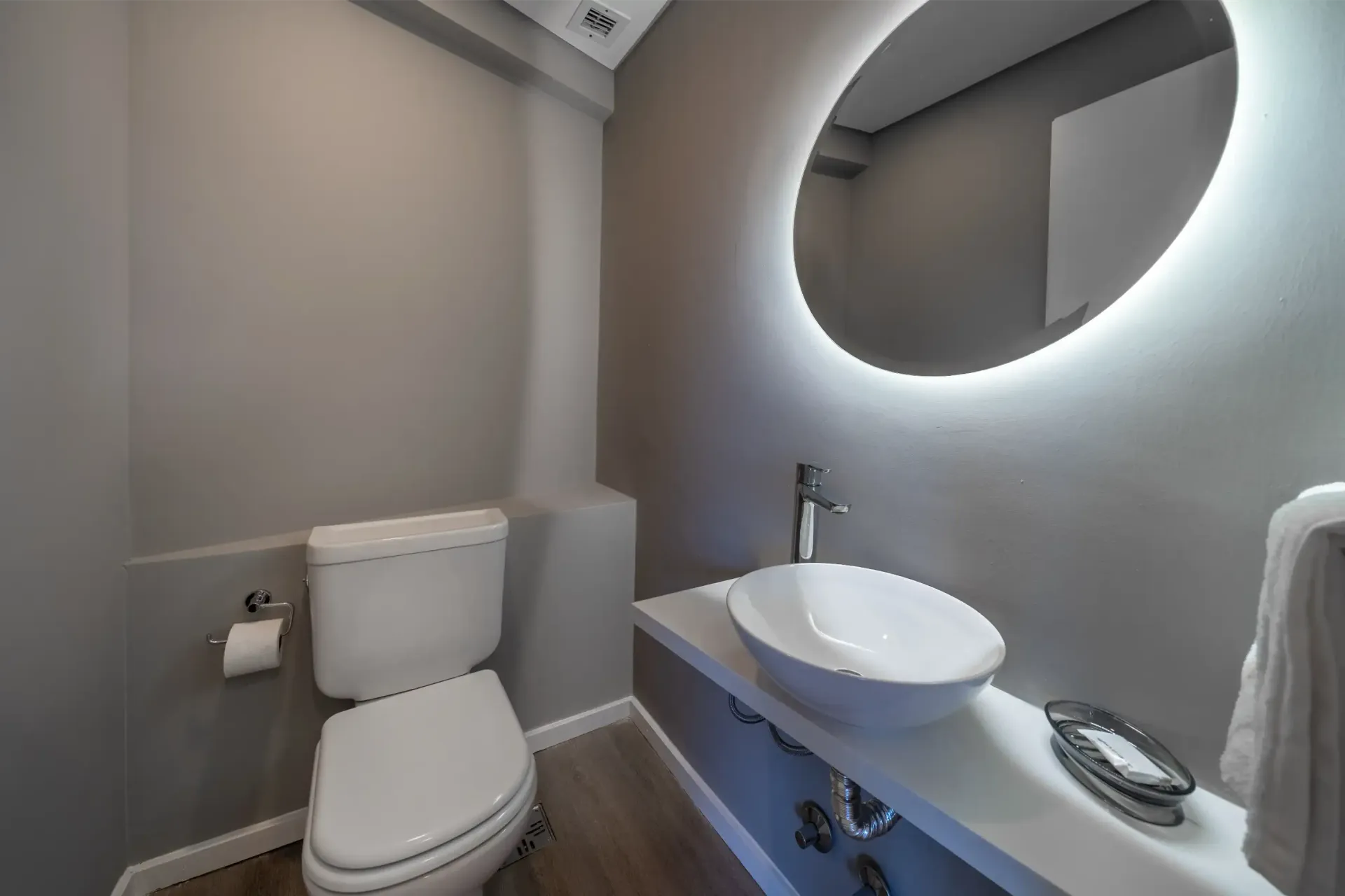 Un baño con inodoro, lavabo y espejo.