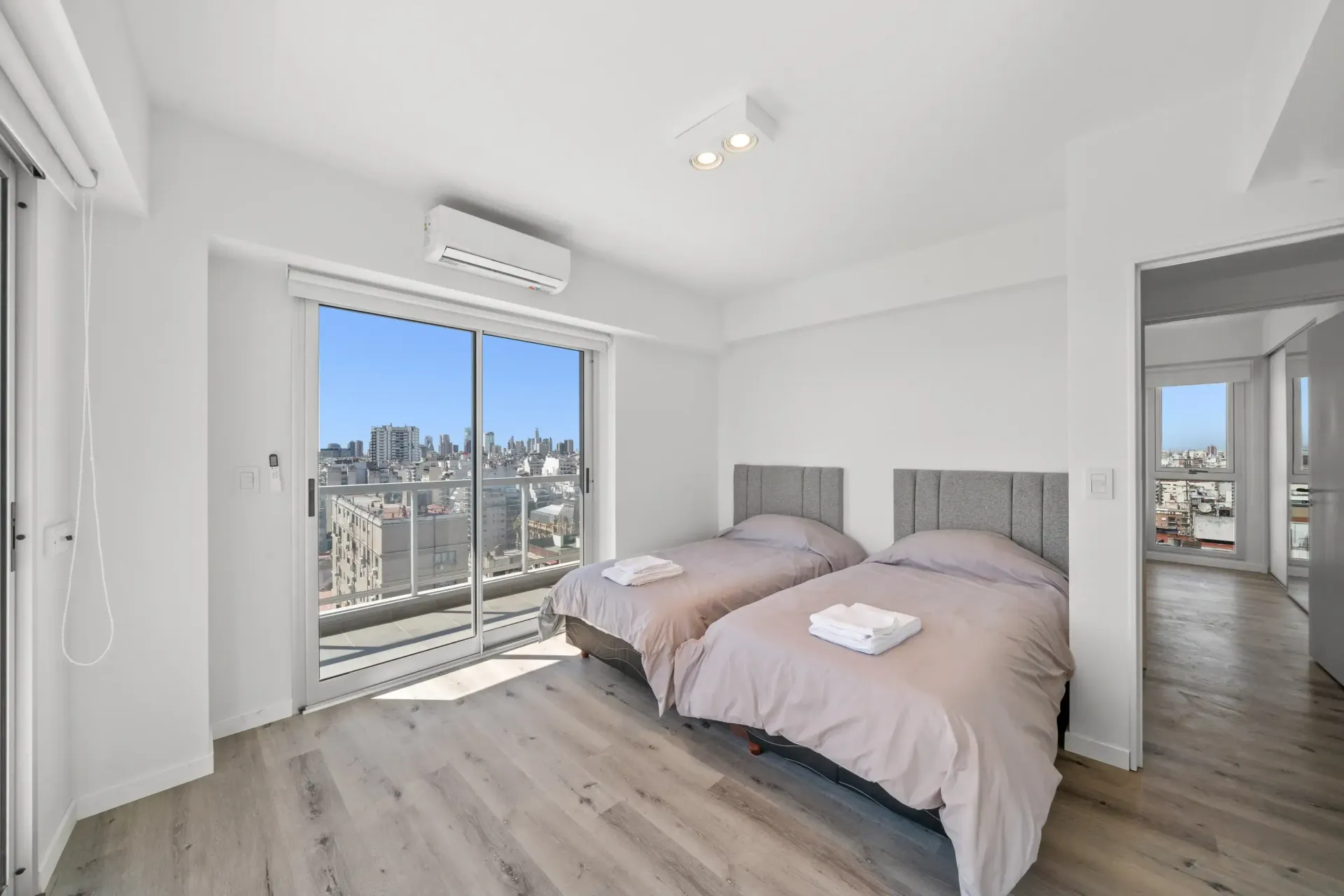Un dormitorio con dos camas y una gran ventana.