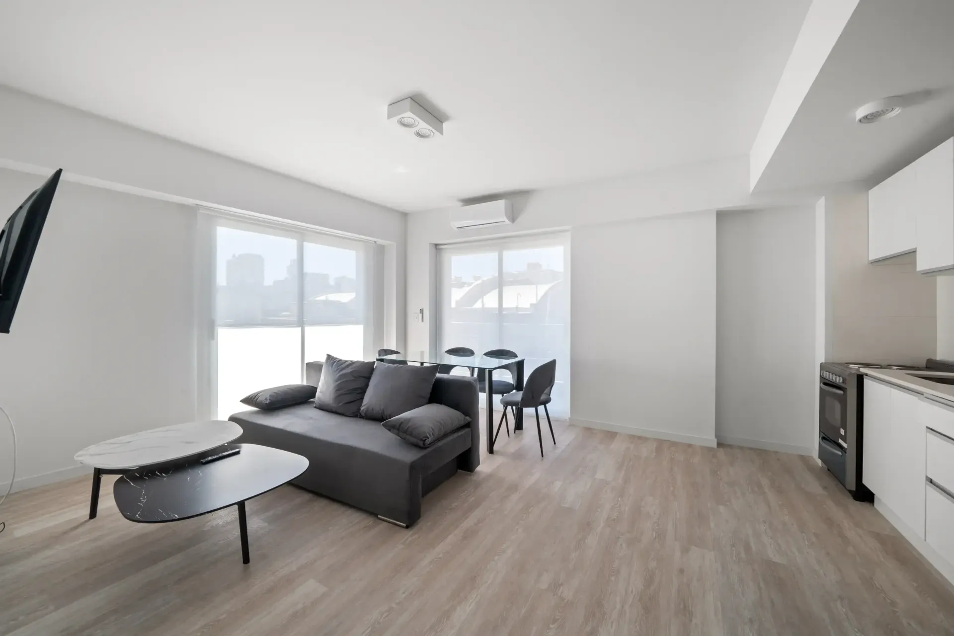 Una sala de estar con sofá, mesa y televisión.