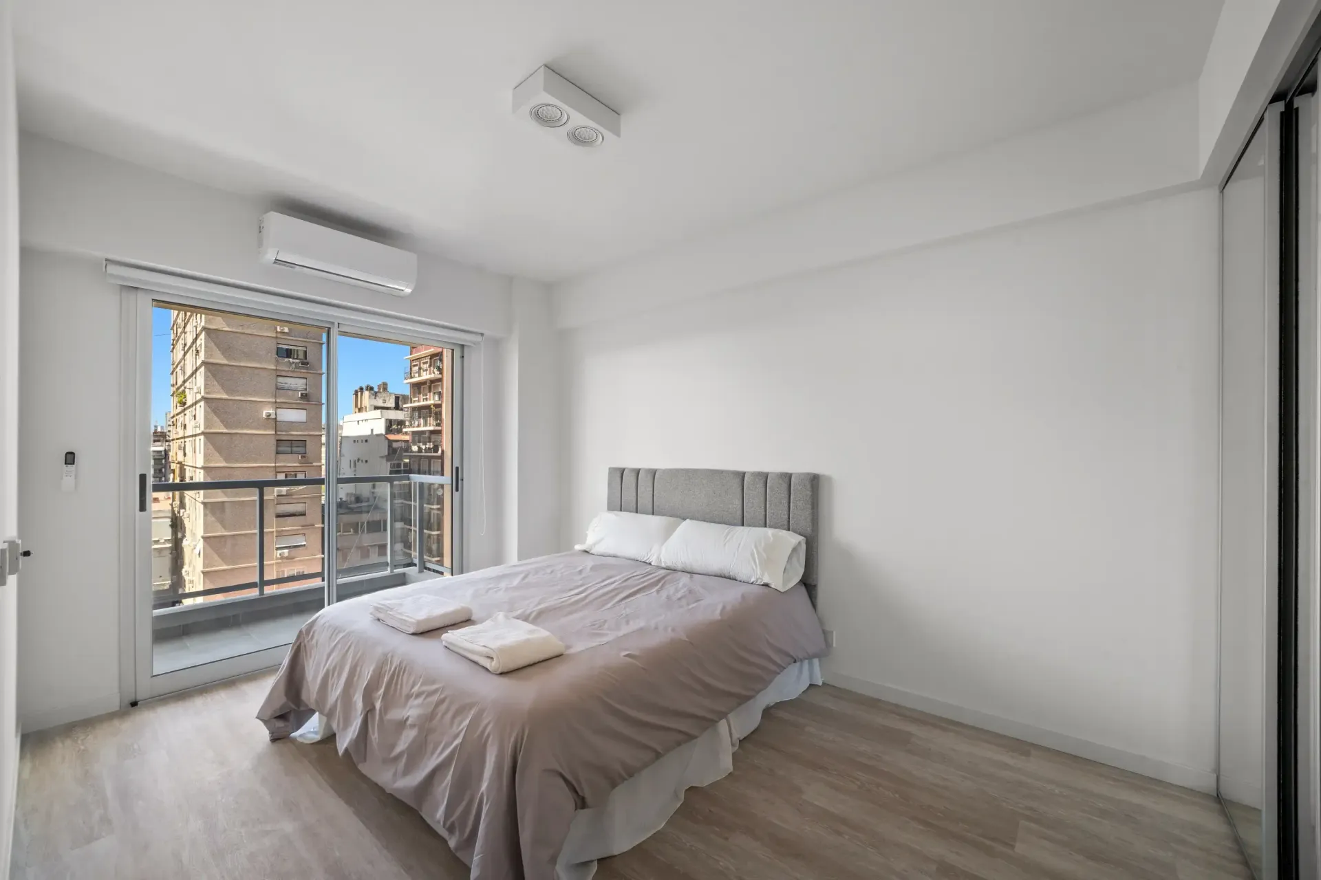 Un dormitorio con una cama grande y un balcón.