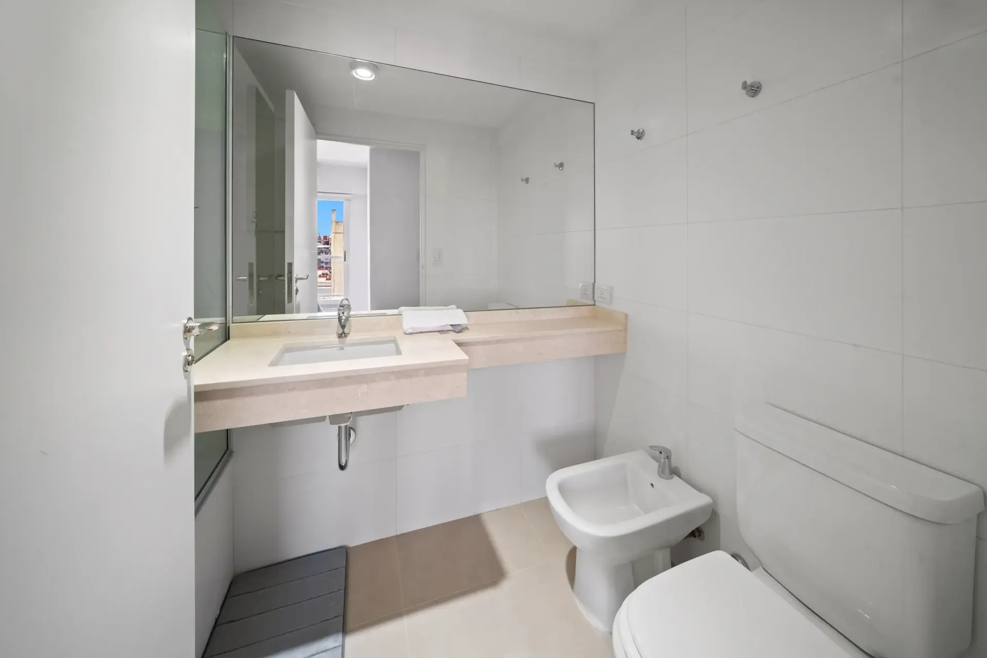 Un baño con inodoro, lavabo y espejo.
