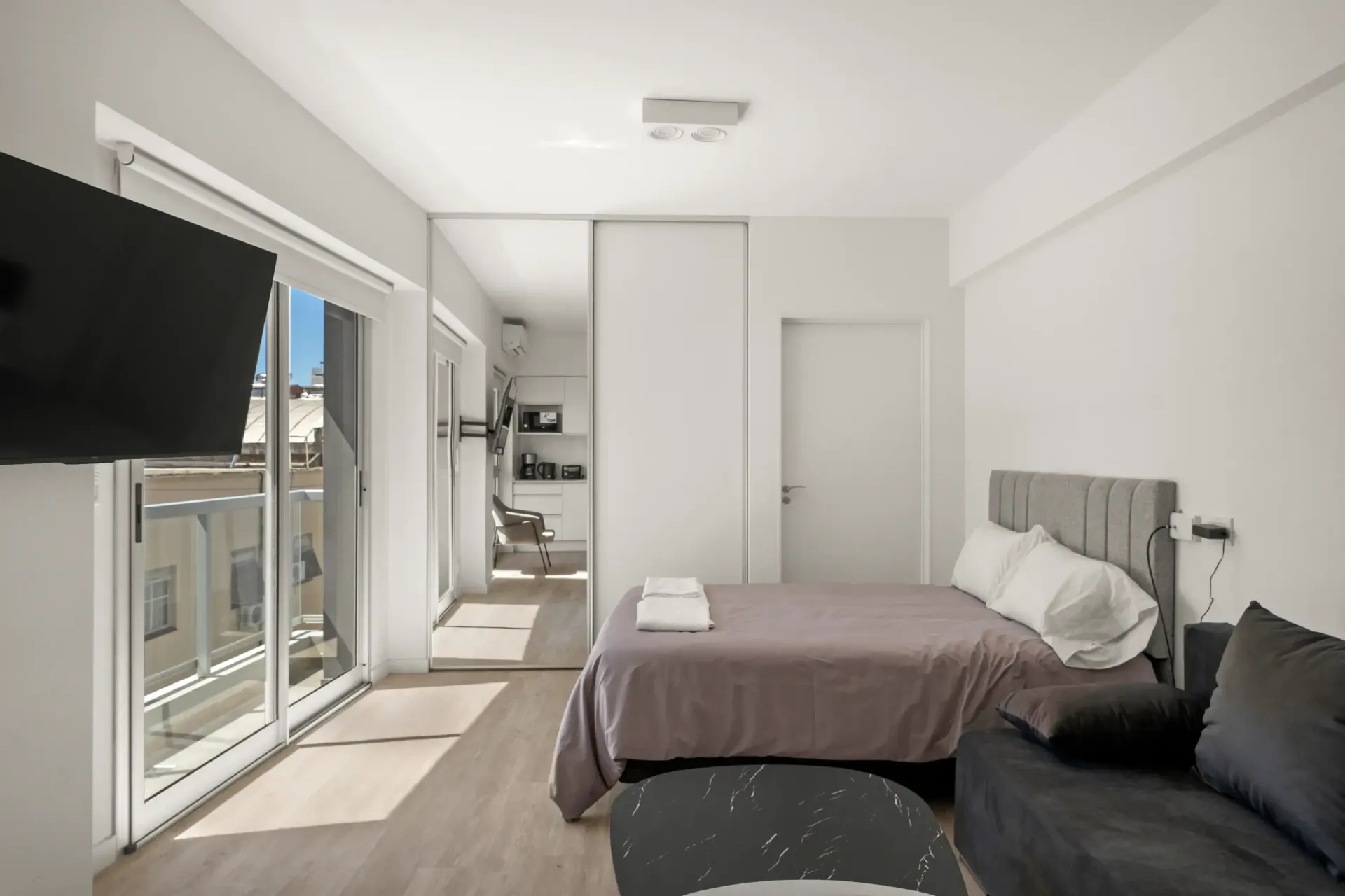 Un dormitorio con una cama grande y un televisor de pantalla plana.