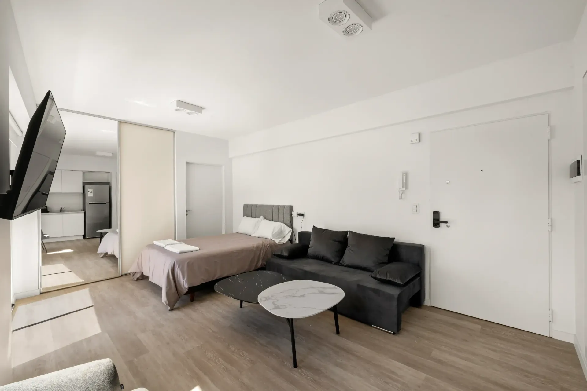 Un dormitorio con cama, sofá, mesa de café y televisión.